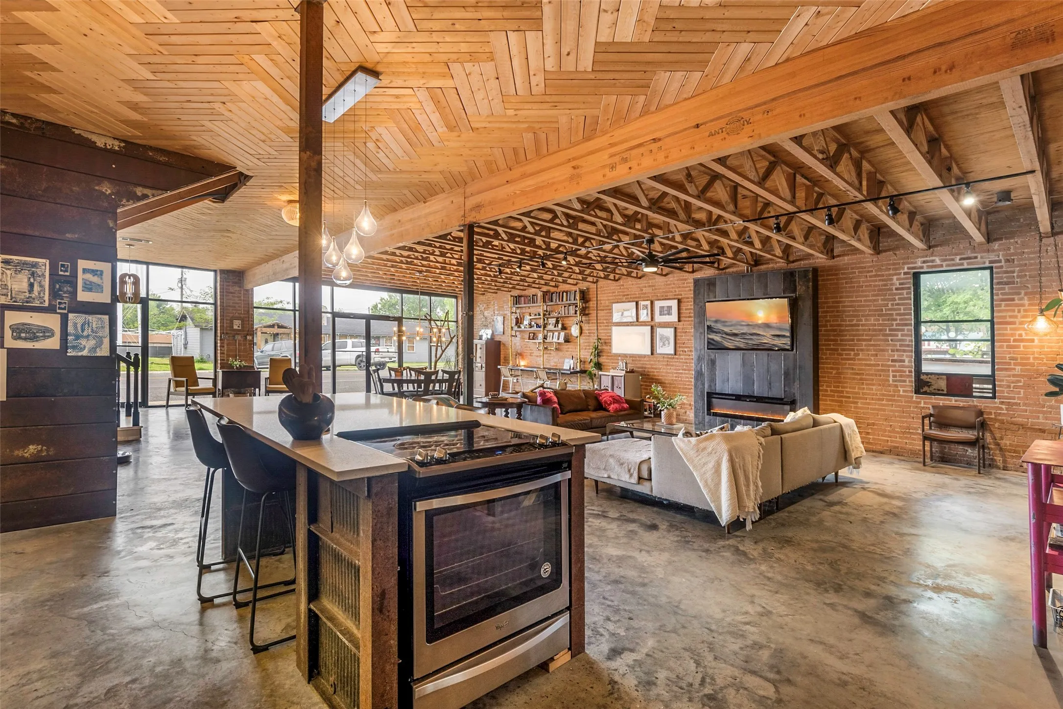 Kitchen featuring a kitchen island, a breakfast bar, hanging light fixtures, brick wall, and wooden ceiling