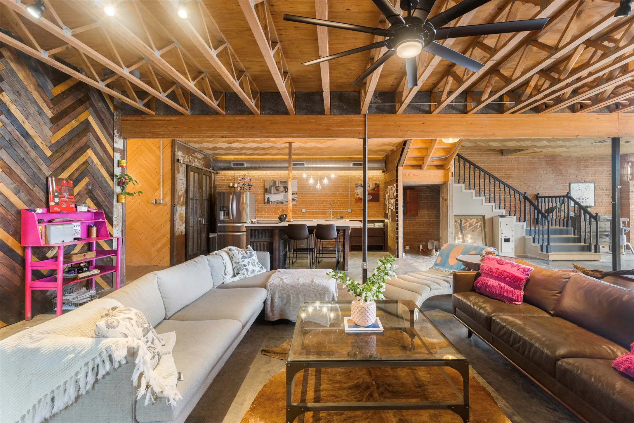 Basement featuring ceiling fan, brick wall, and stainless steel fridge
