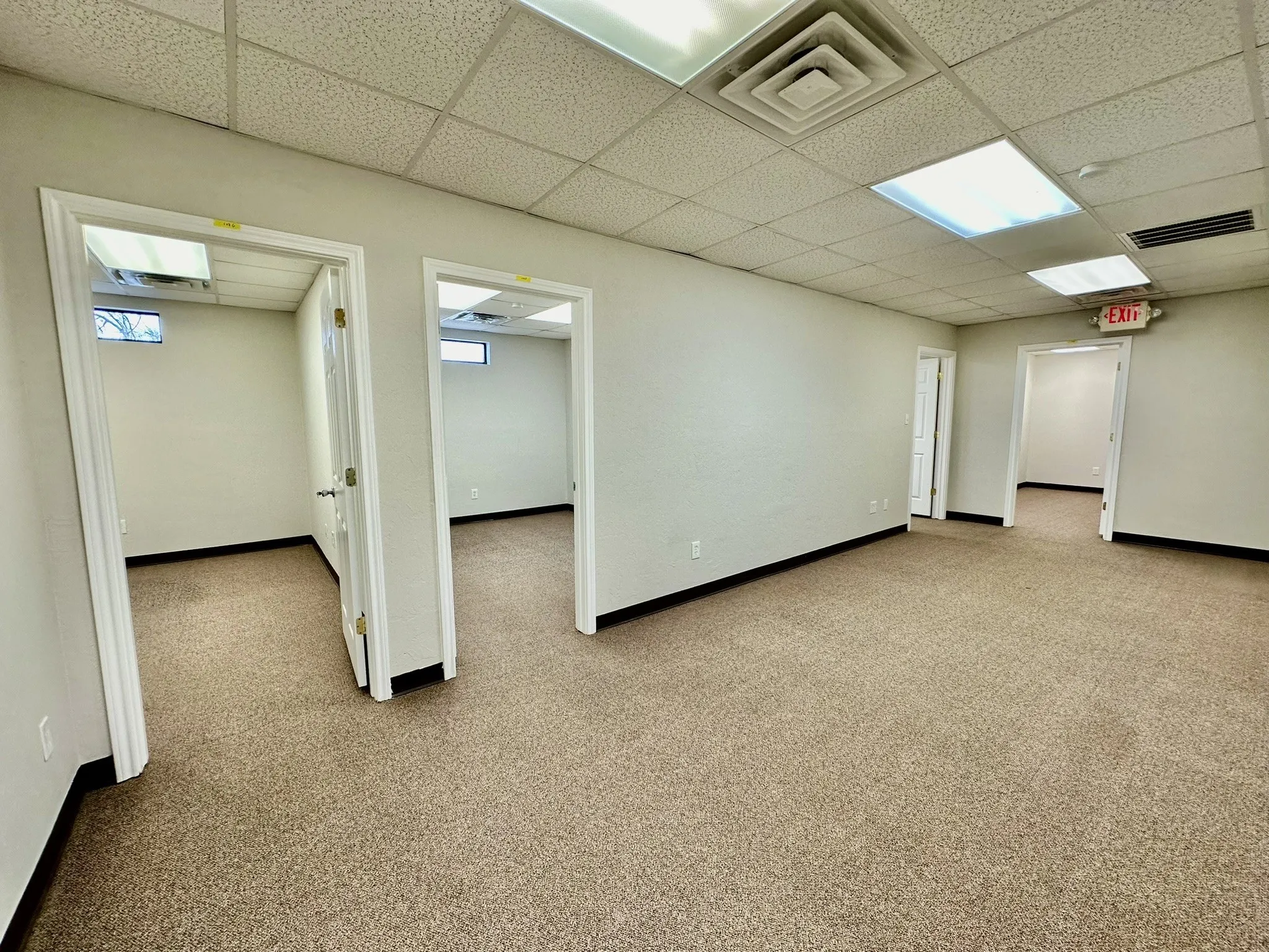 Spare room with a drop ceiling and carpet flooring