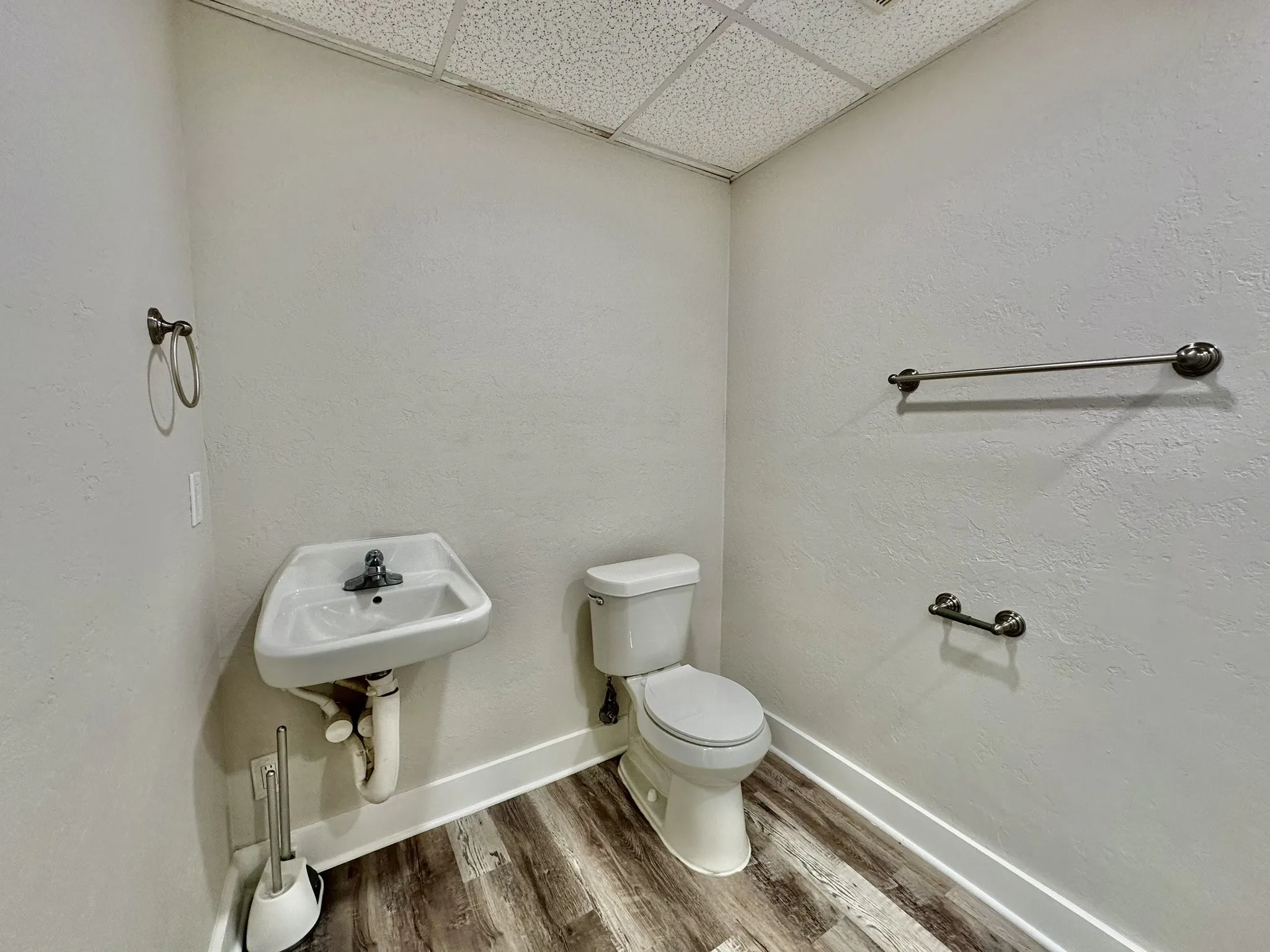 Bathroom with sink, toilet, a paneled ceiling, and hardwood / wood-style floors