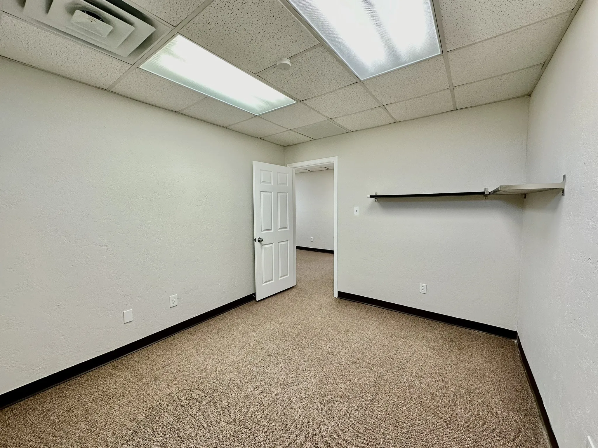 Spare room featuring a paneled ceiling and carpet flooring