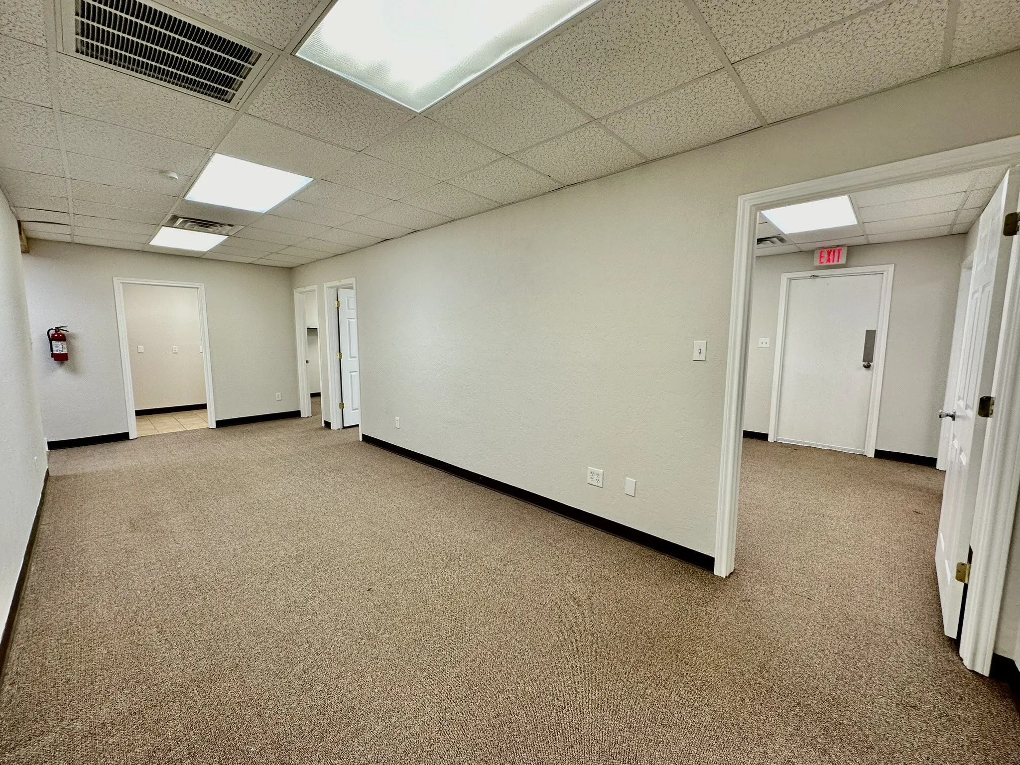 Spare room with a paneled ceiling and carpet