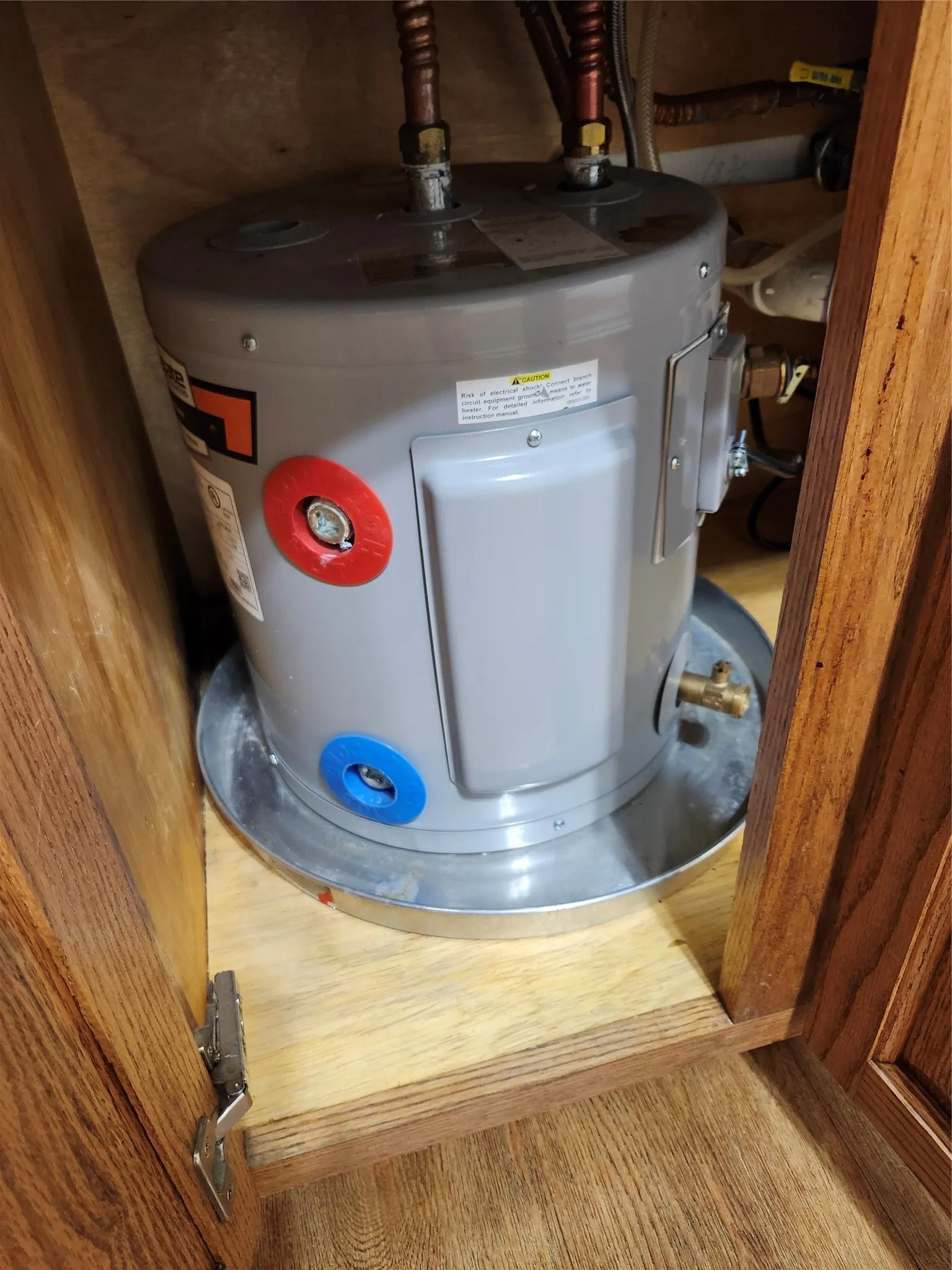 Electric water heater under kitchen sink.
