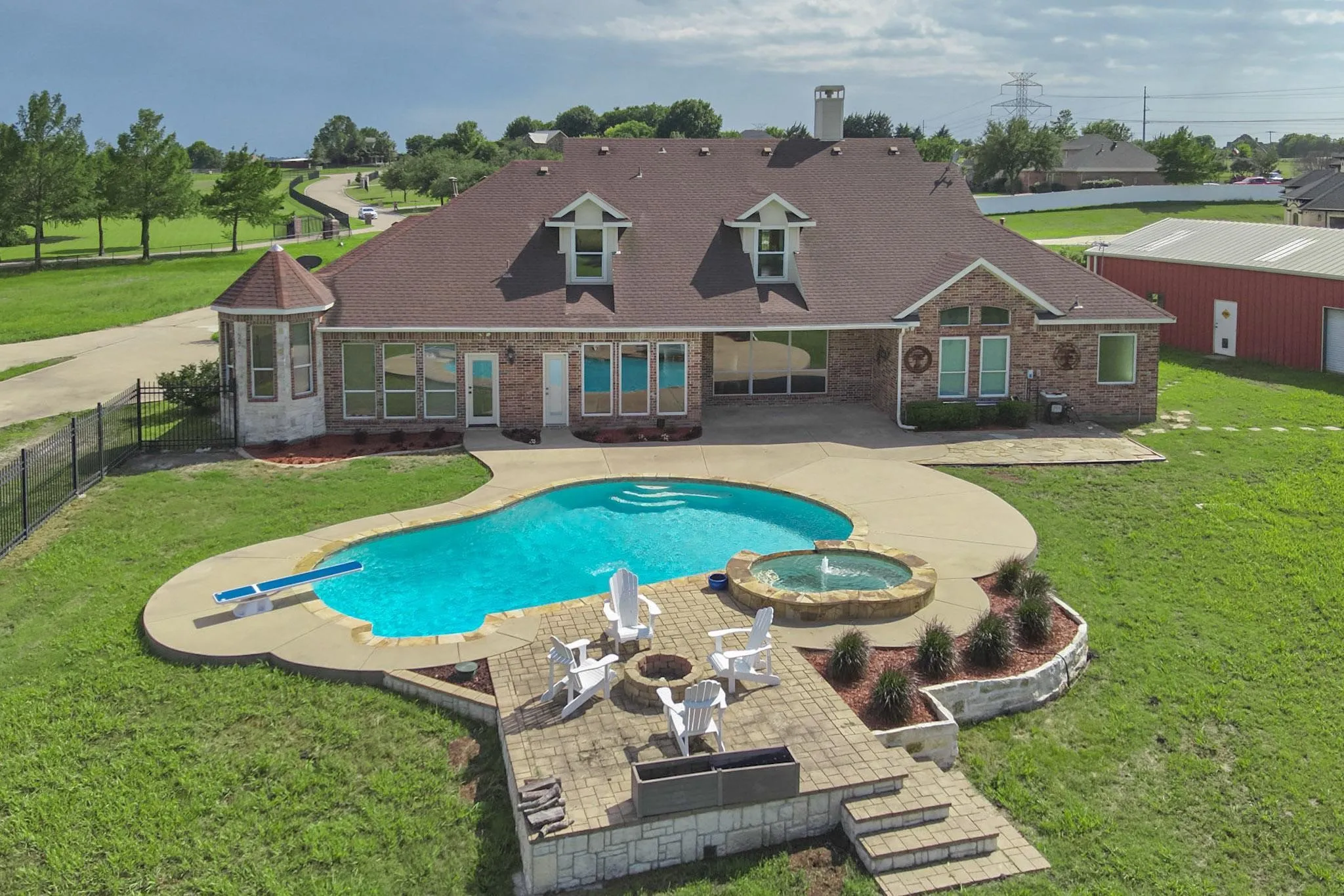 View of swimming pool featuring an in ground hot tub, an outdoor fire pit, a patio, and a lawn