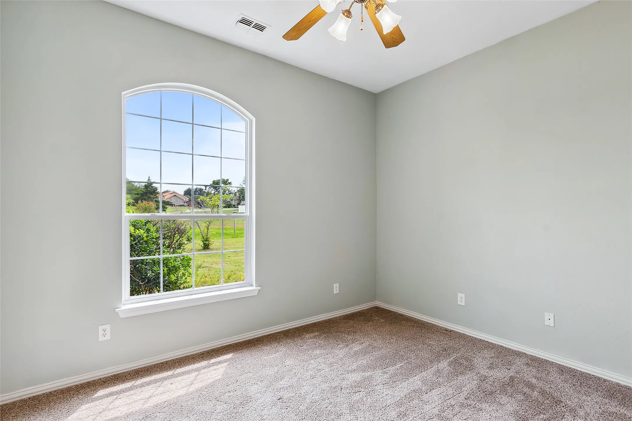 Carpeted empty room with ceiling fan