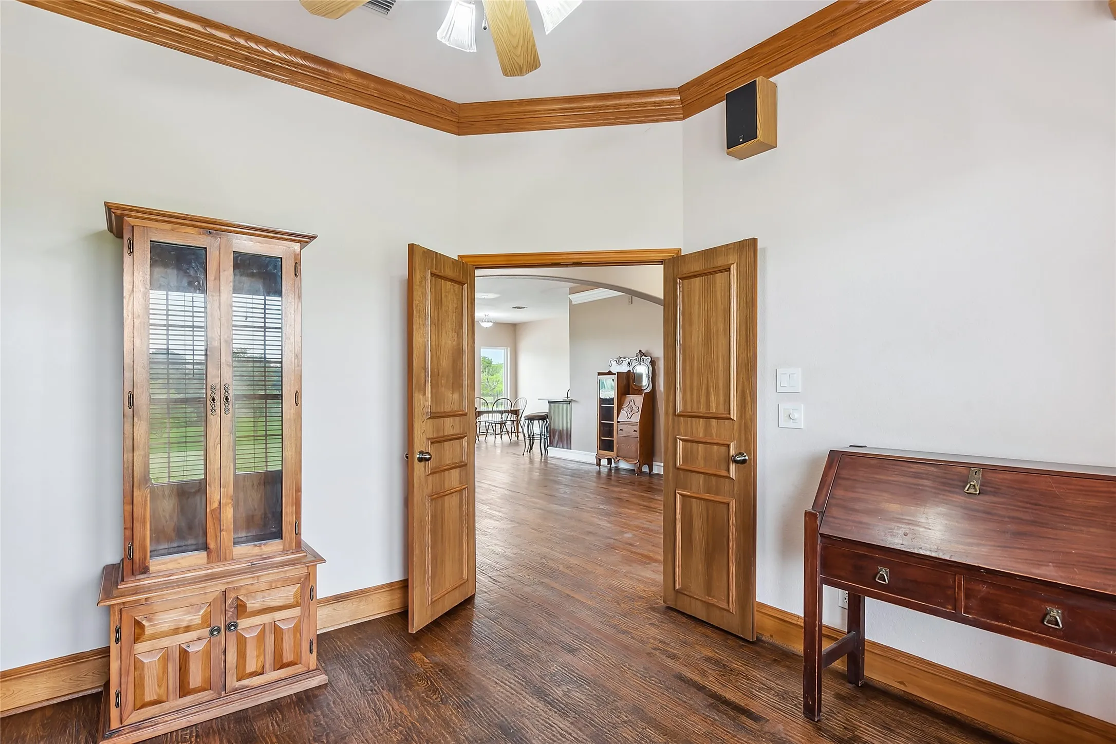 Study featuring dark hardwood / wood-style floors and crown molding