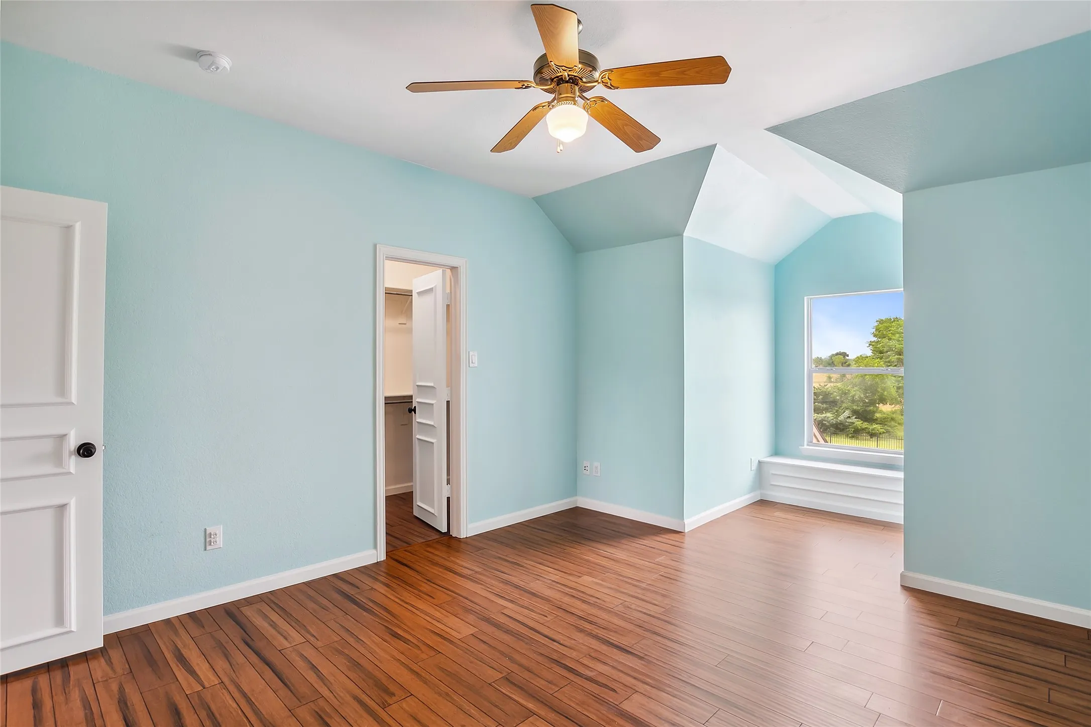 Spare room with hardwood / wood-style flooring, ceiling fan, and lofted ceiling