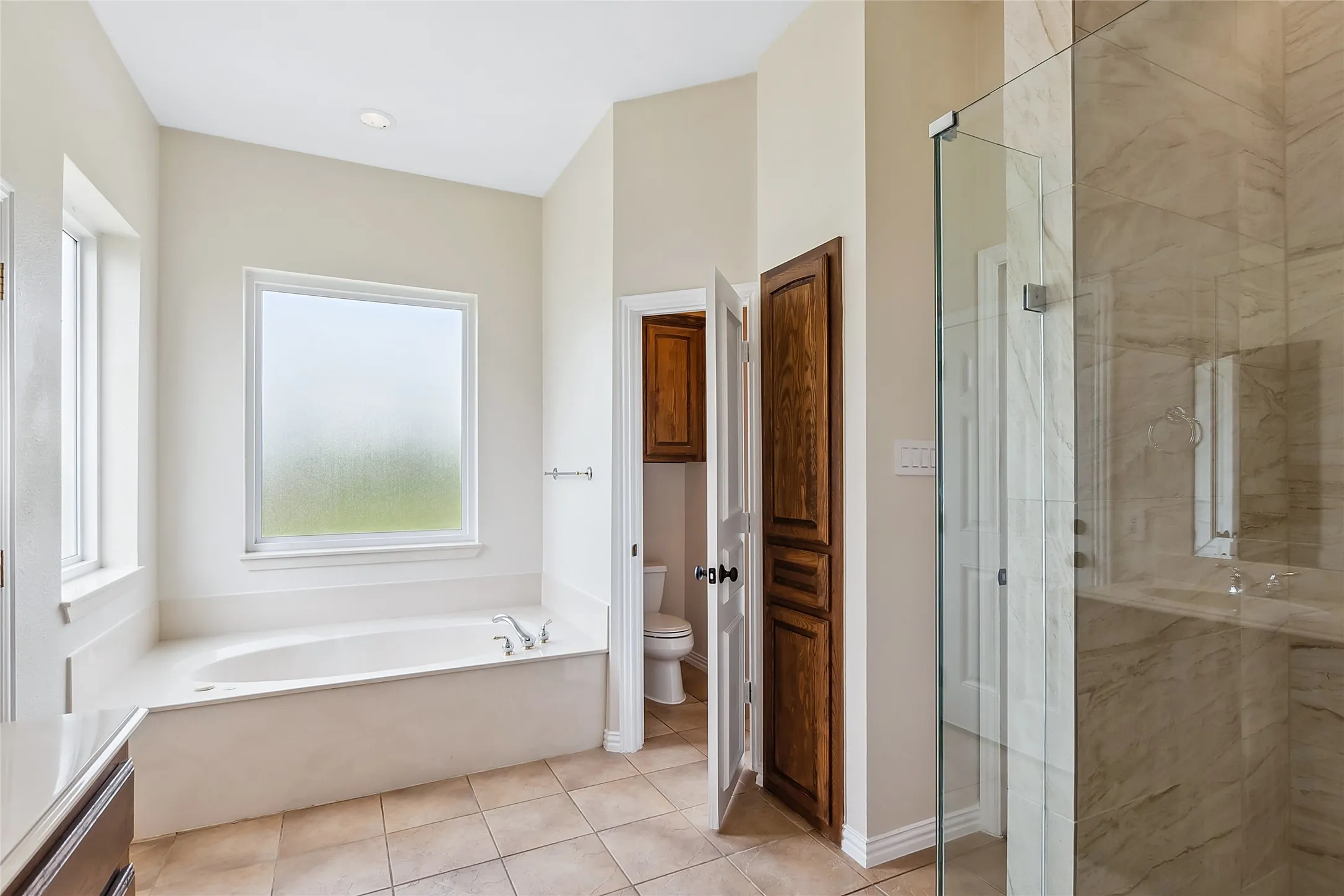 Full bathroom featuring sink, tile flooring, separate shower and tub, and toilet