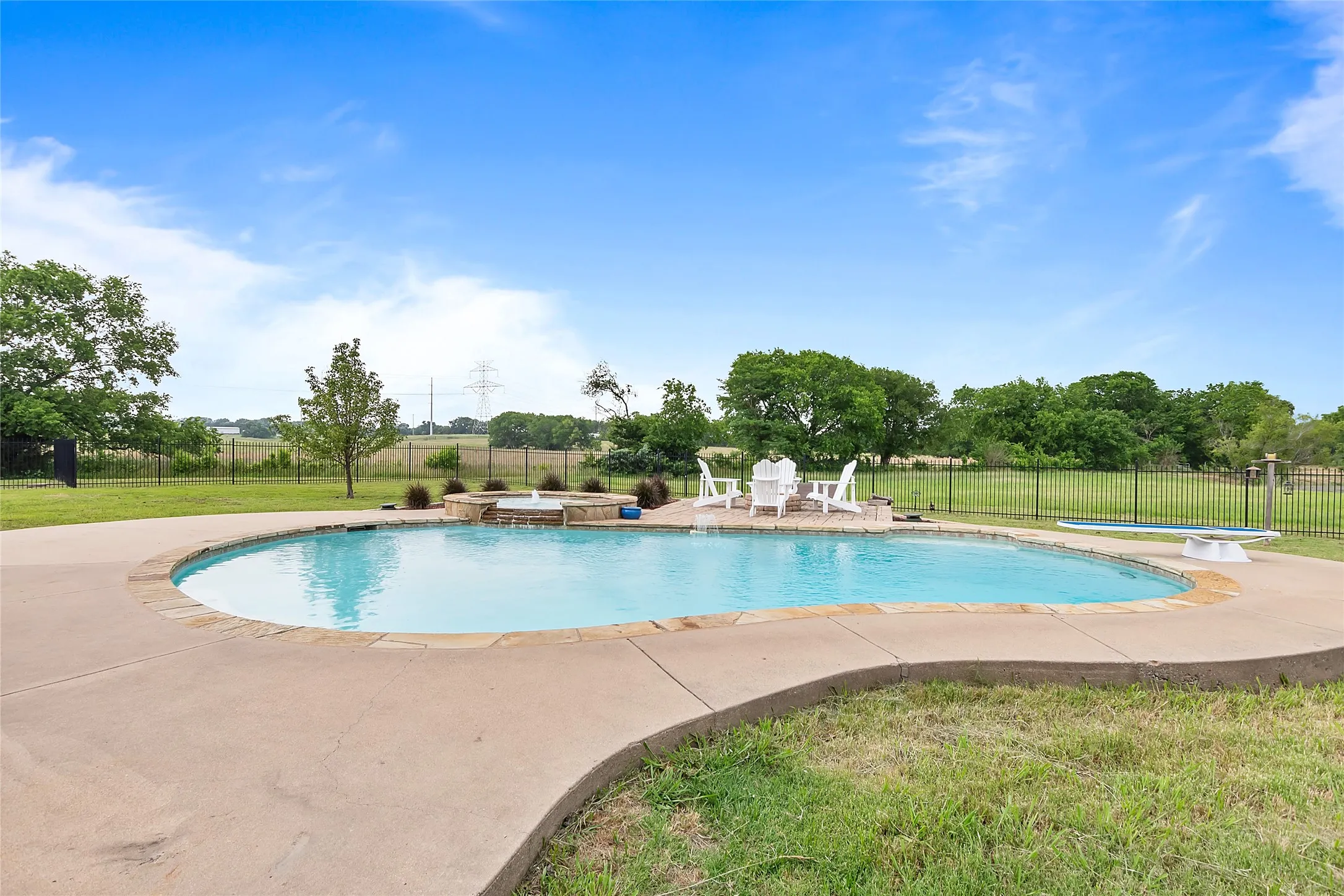 View of swimming pool with a diving board, a lawn, and a patio area