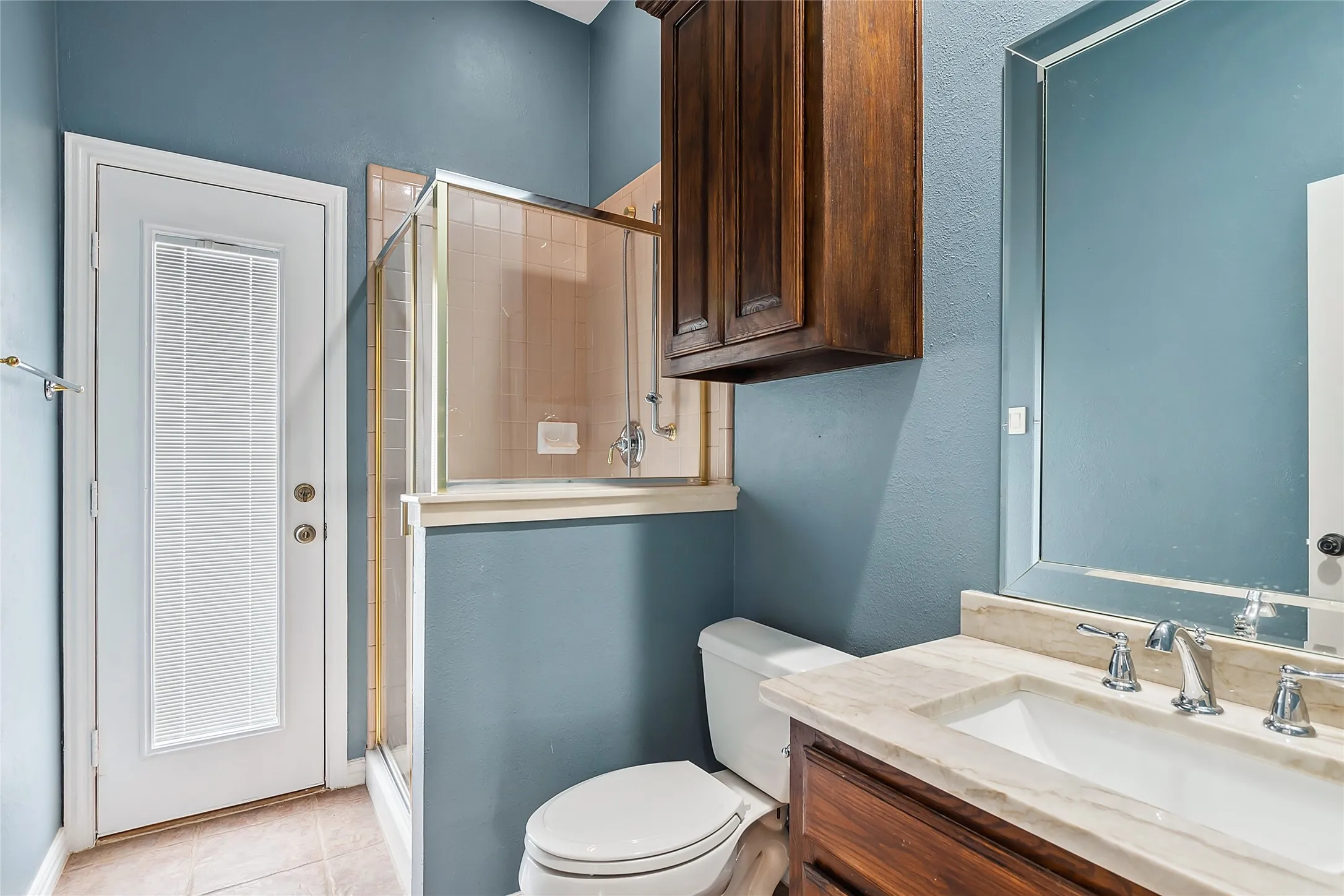 Bathroom featuring walk in shower, tile flooring, vanity, and toilet