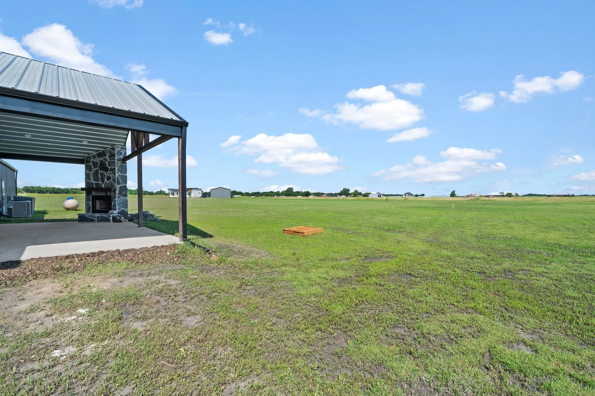 View of yard with a rural view, an outdoor structure, and central AC