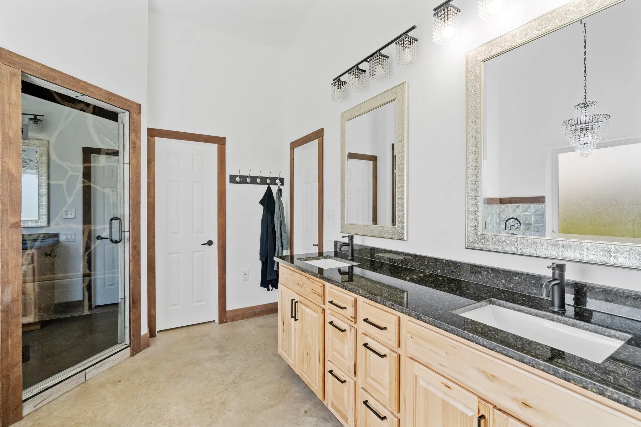 Bathroom with walk in shower, dual bowl vanity, and an inviting chandelier