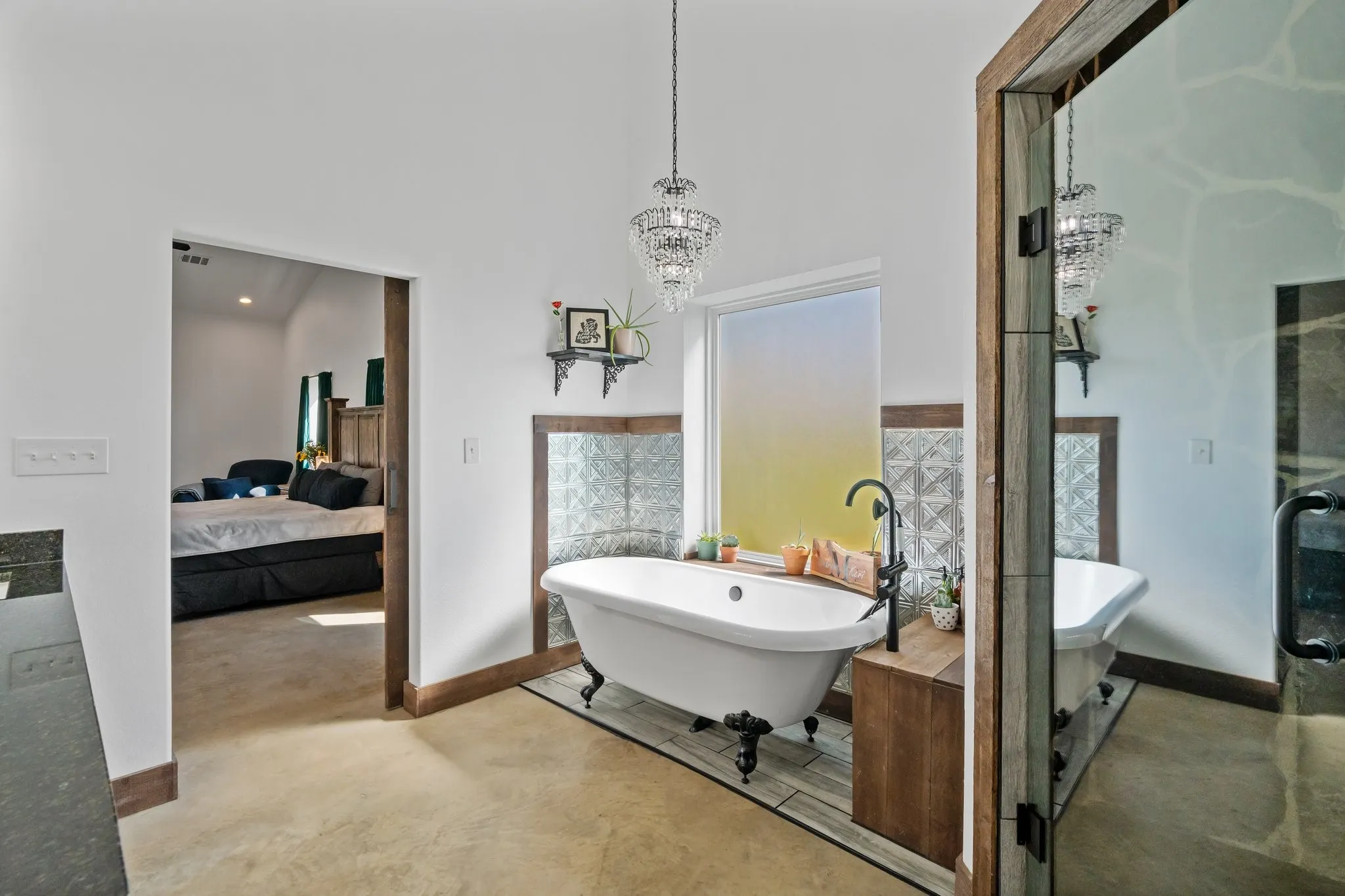 Bathroom featuring plus walk in shower, a towering ceiling, and a chandelier