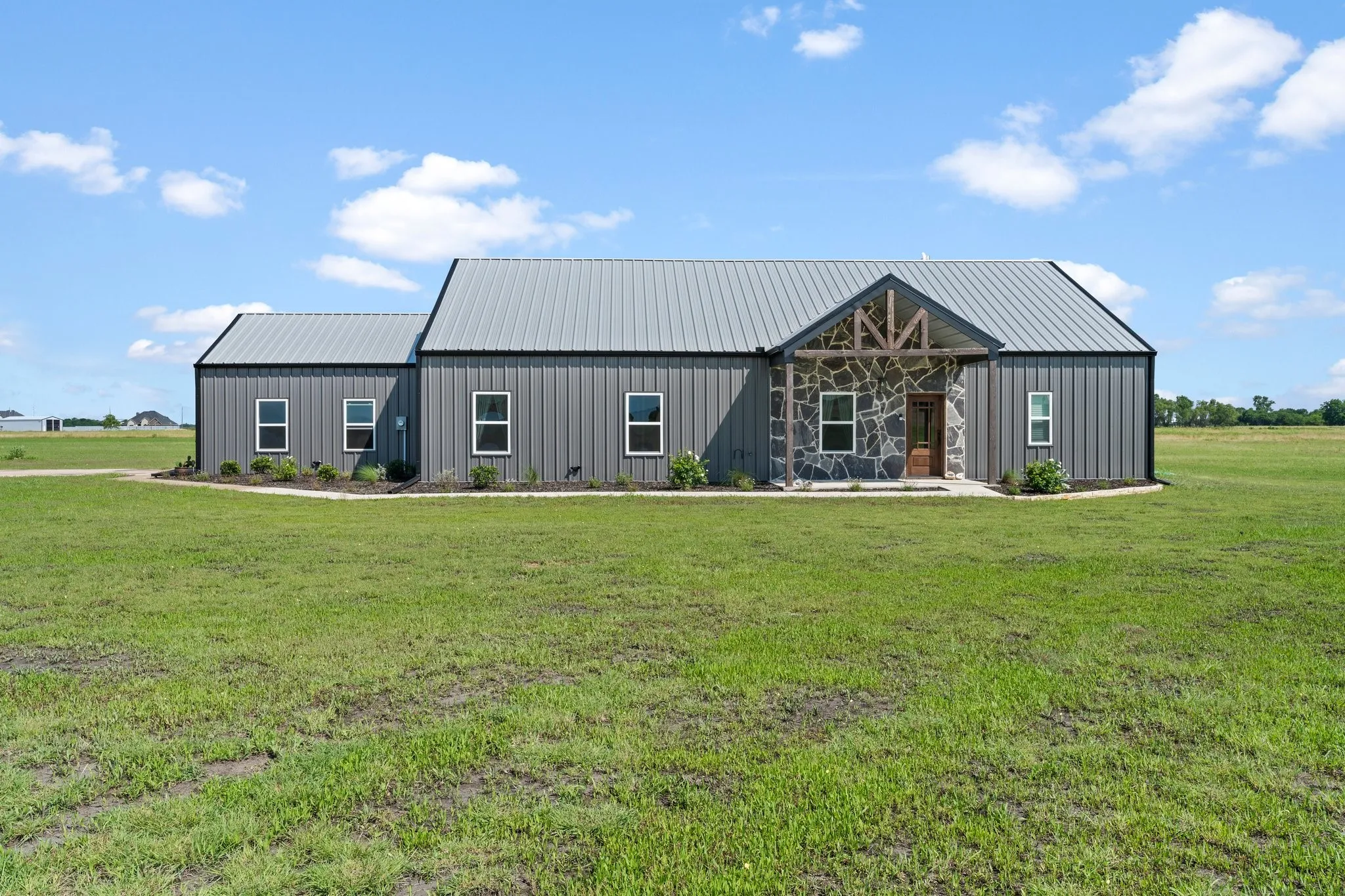 Modern farmhouse style home featuring an outdoor structure and a front lawn