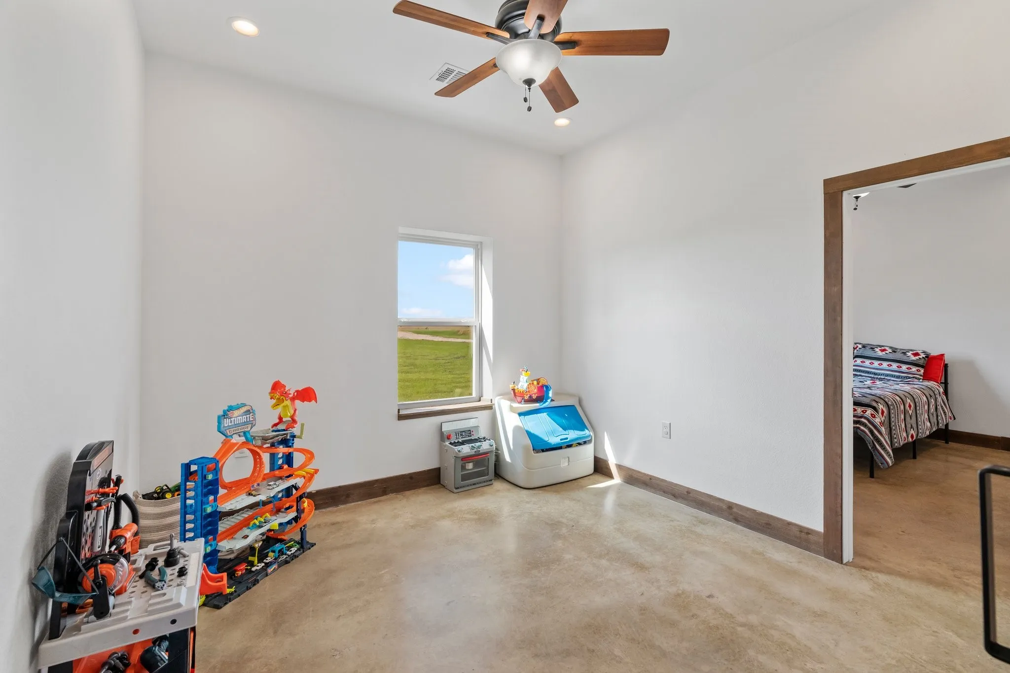 Recreation room featuring concrete floors and ceiling fan