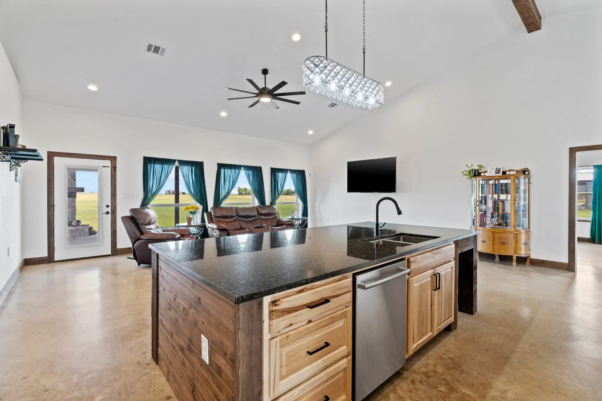 Kitchen featuring an island with sink, sink, ceiling fan, and stainless steel dishwasher