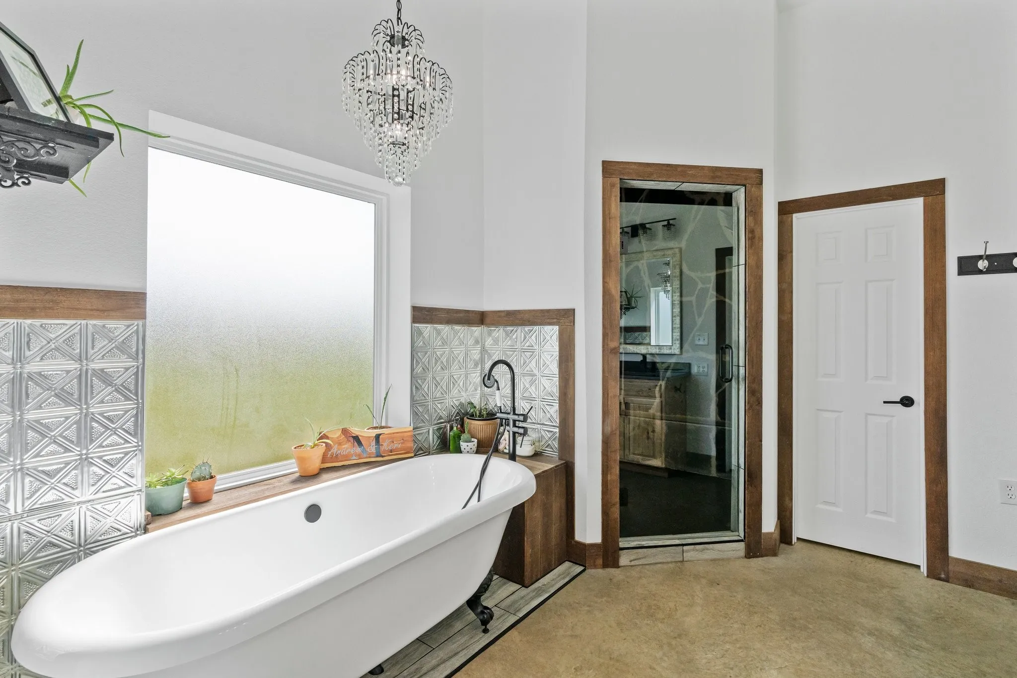 Bathroom featuring an inviting chandelier, separate shower and tub, and tile walls
