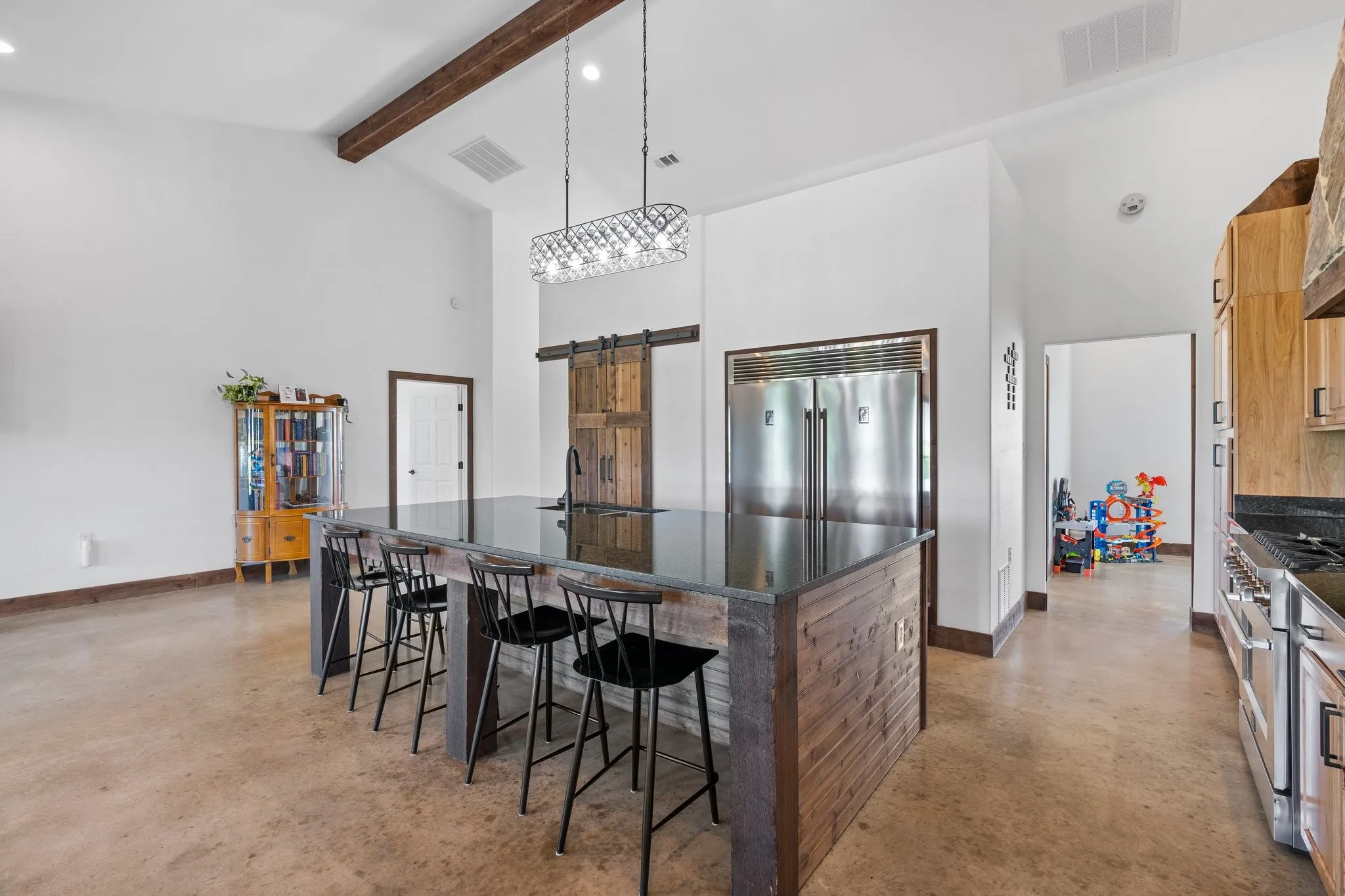 Kitchen with a kitchen bar, a center island, high vaulted ceiling, high quality appliances, and pendant lighting