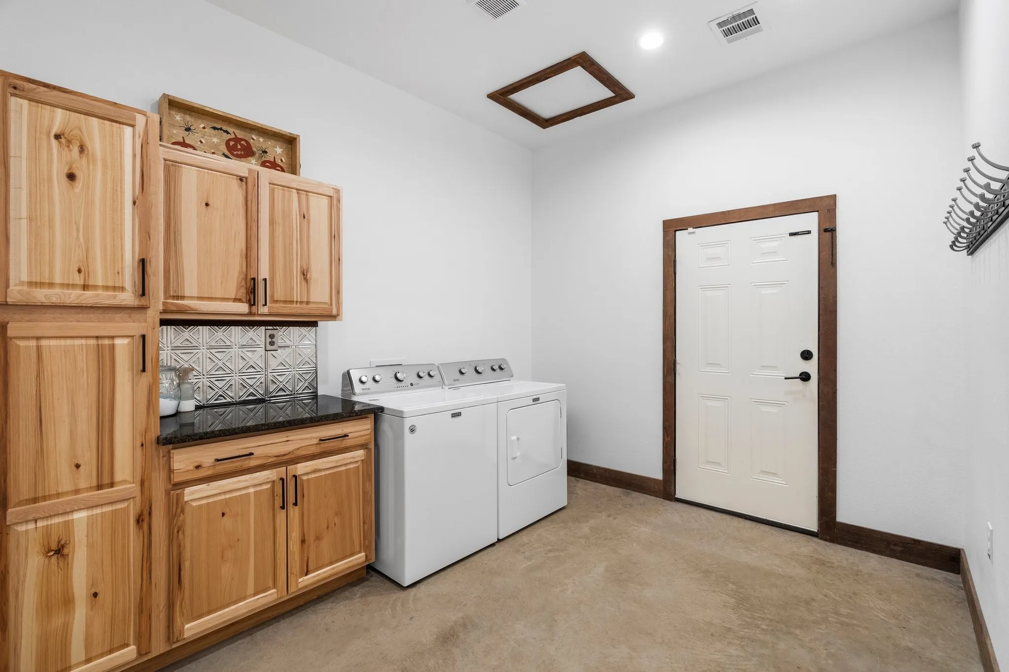 Laundry room featuring separate washer and dryer and cabinets
