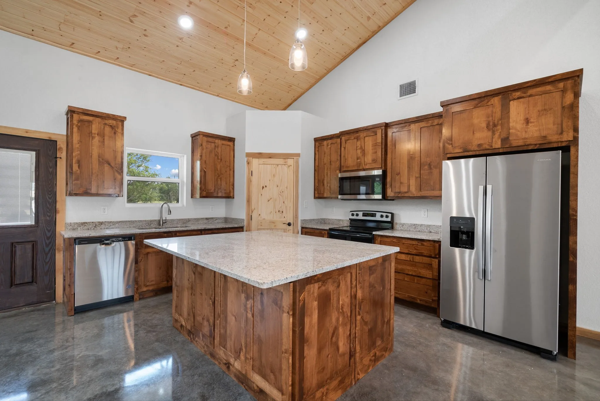 Kitchen with a kitchen island, appliances with stainless steel finishes, high vaulted ceiling, sink, and wood ceiling