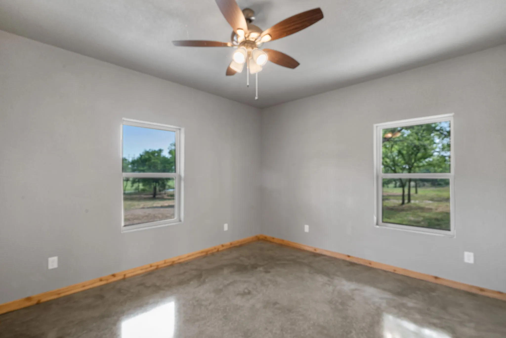 Empty room with ceiling fan, a wealth of natural light, and carpet flooring