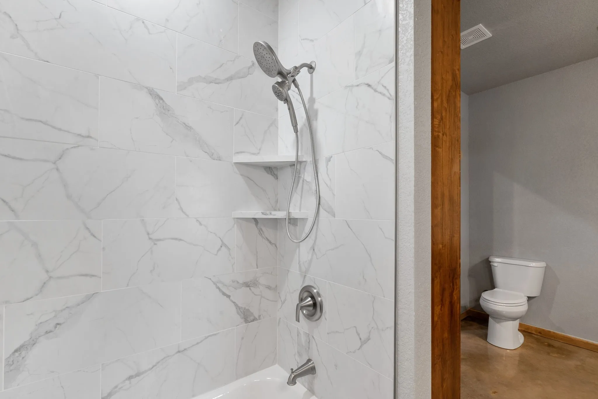 Bathroom with tiled shower / bath and toilet