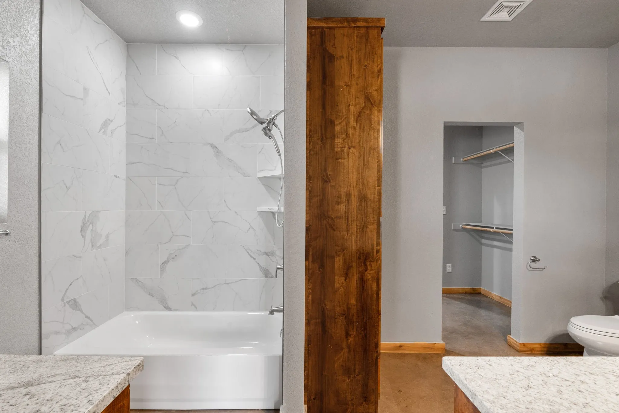 Full bathroom with tiled shower / bath combo, vanity, and toilet