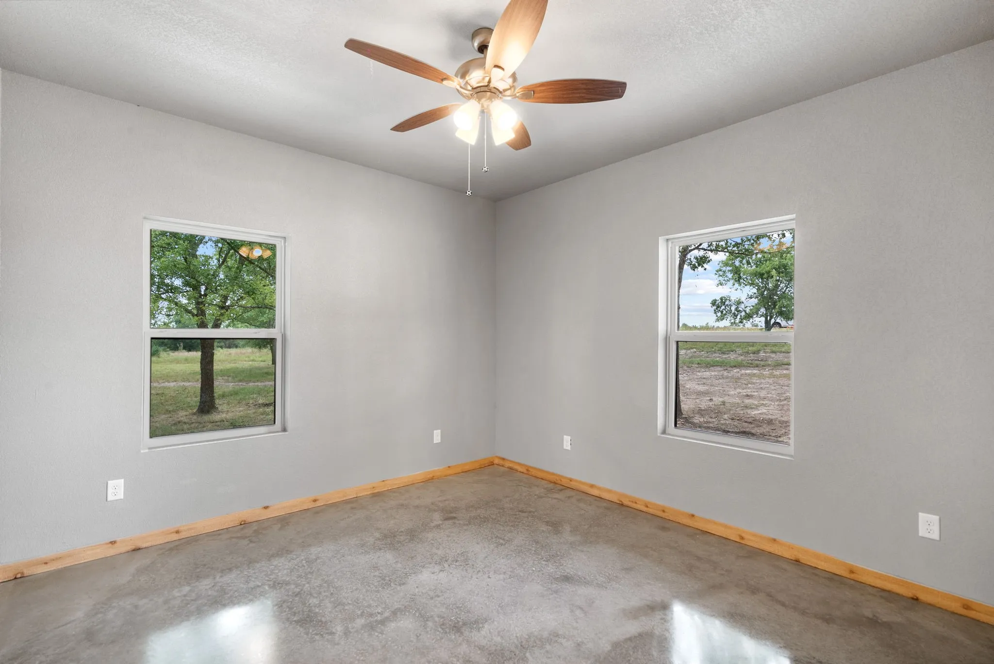 Unfurnished room featuring ceiling fan, a textured ceiling, and concrete flooring
