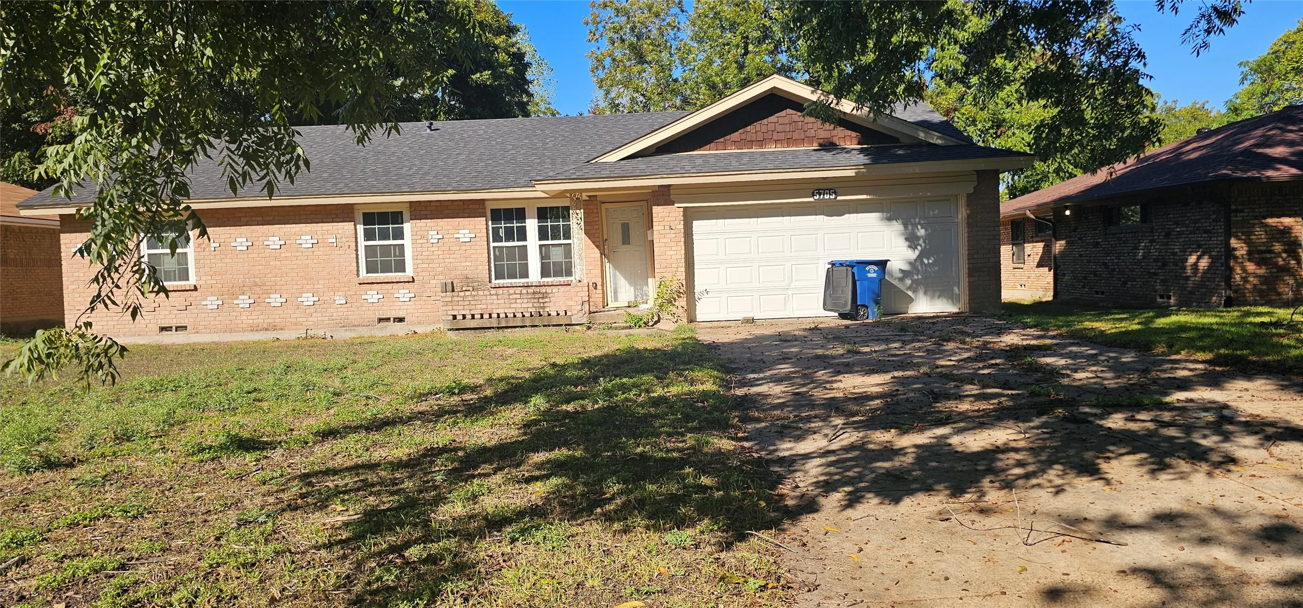 Brick exterior, attached garage, white garage door, gabled roofline, front entry door