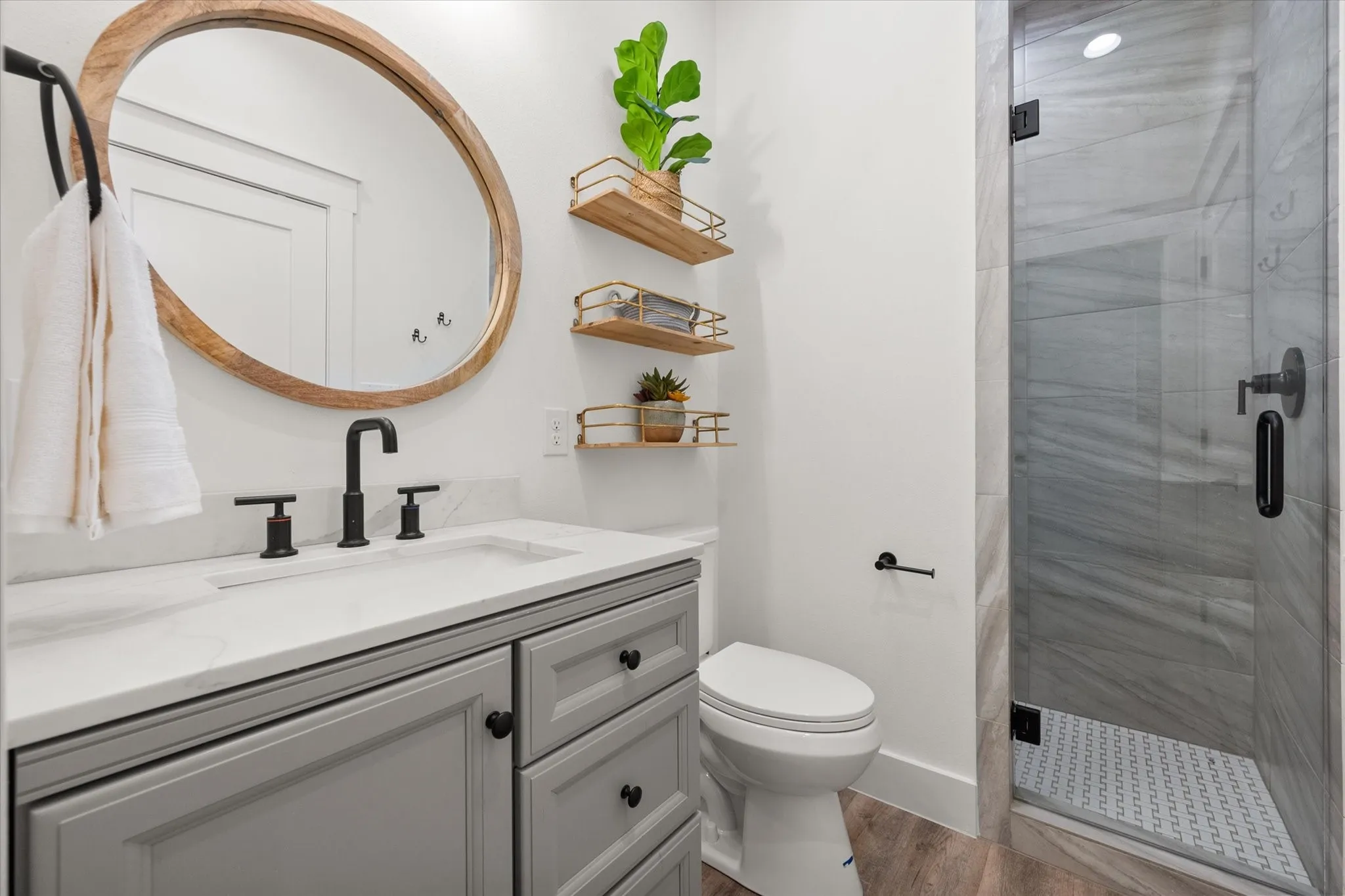 Bathroom with a shower with door, hardwood / wood-style flooring, toilet, and vanity