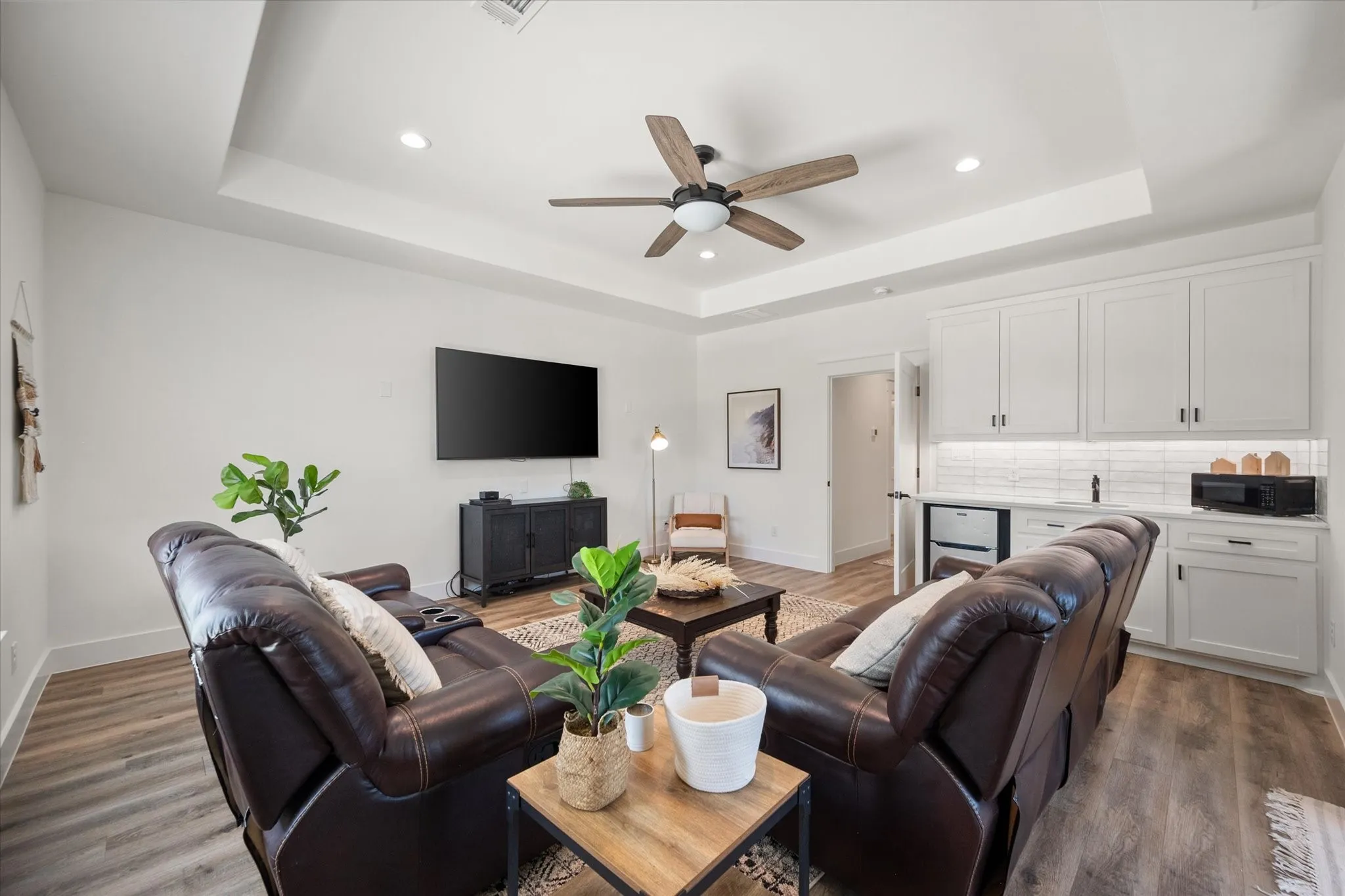 Second Living or flex room featuring wood-type flooring, ceiling fan, and a tray ceiling