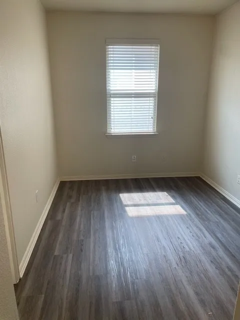 Unfurnished room with dark hardwood / wood-style flooring