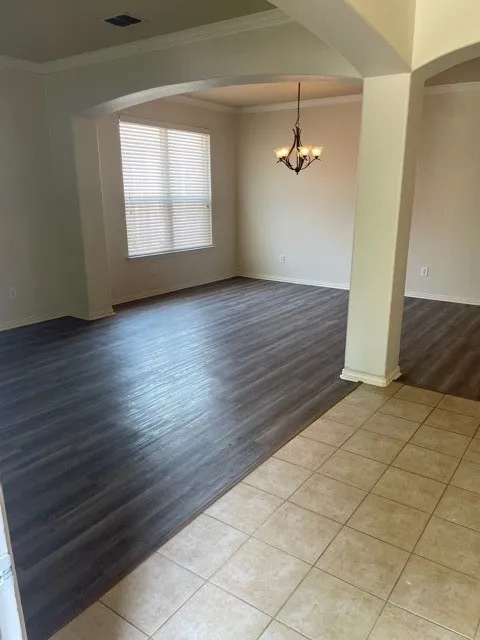 Unfurnished room with wood-type flooring, a chandelier, and crown molding