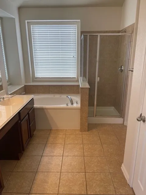 Bathroom with independent shower and bath, vanity, and tile floors