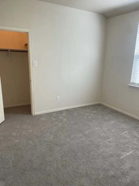 Unfurnished bedroom featuring a spacious closet and carpet