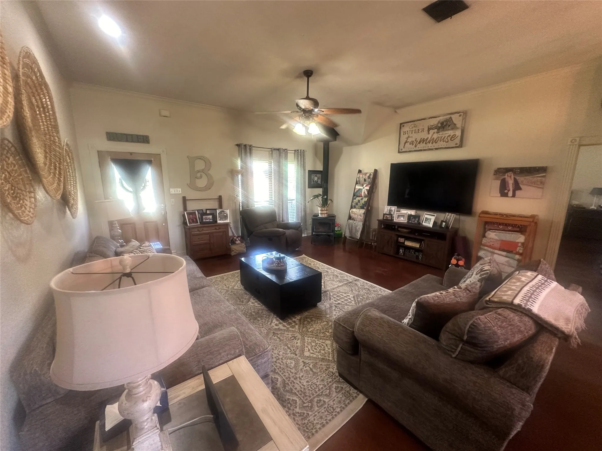 Living room featuring hardwood / wood-style flooring, ornamental molding, and ceiling fan