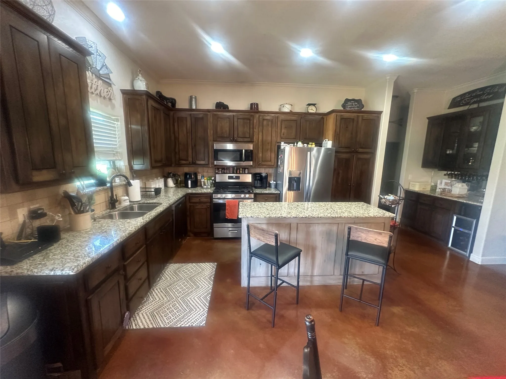 Kitchen featuring stainless steel appliances, tasteful backsplash, a kitchen island, and sink