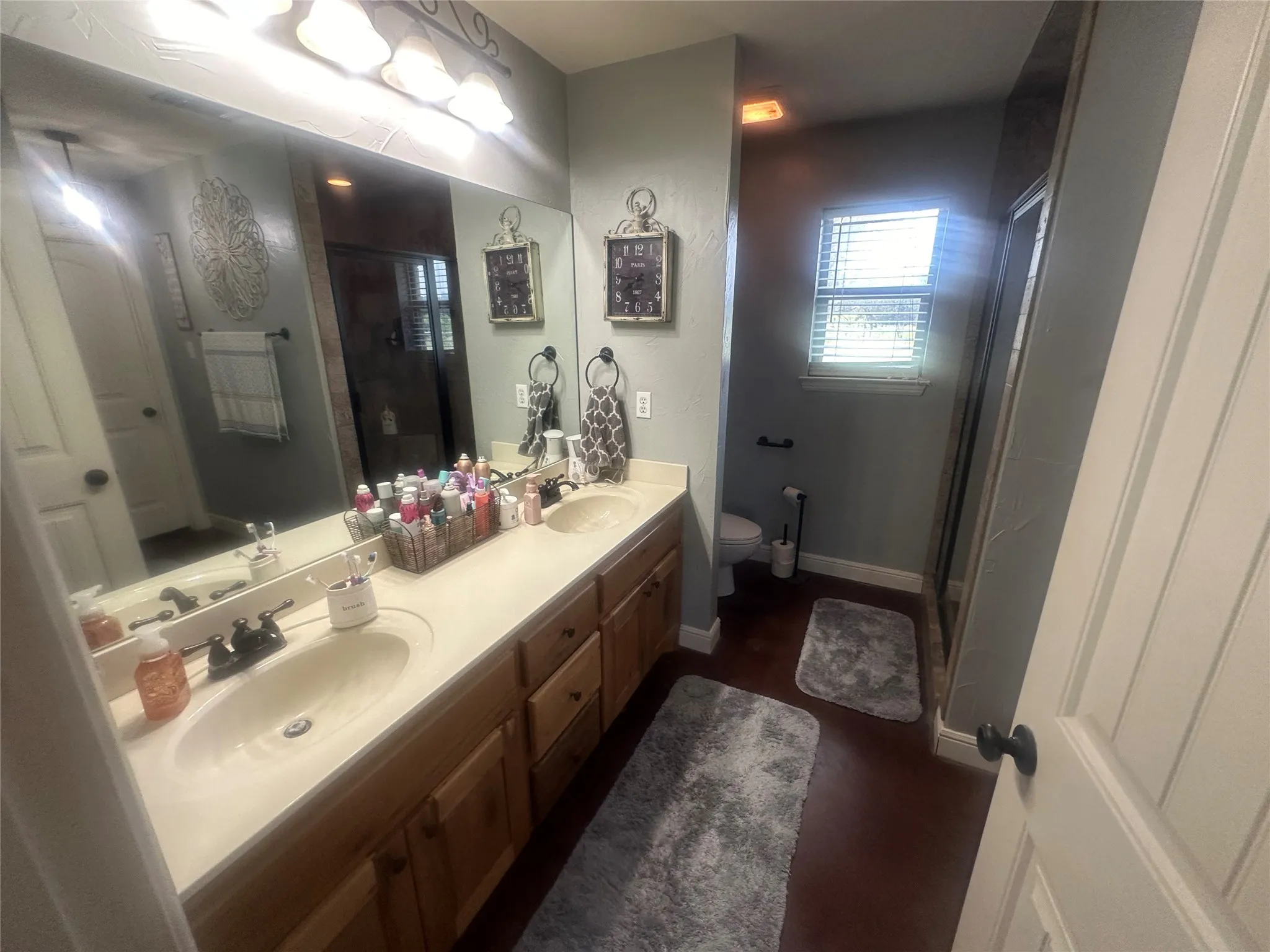 Bathroom featuring hardwood / wood-style floors, double vanity, and toilet