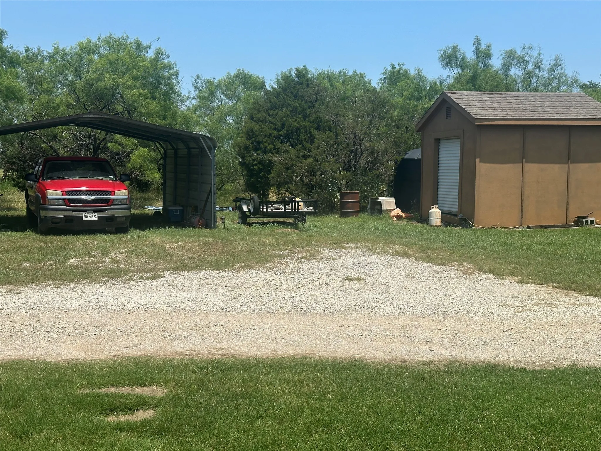 View of yard featuring a shed and a carport