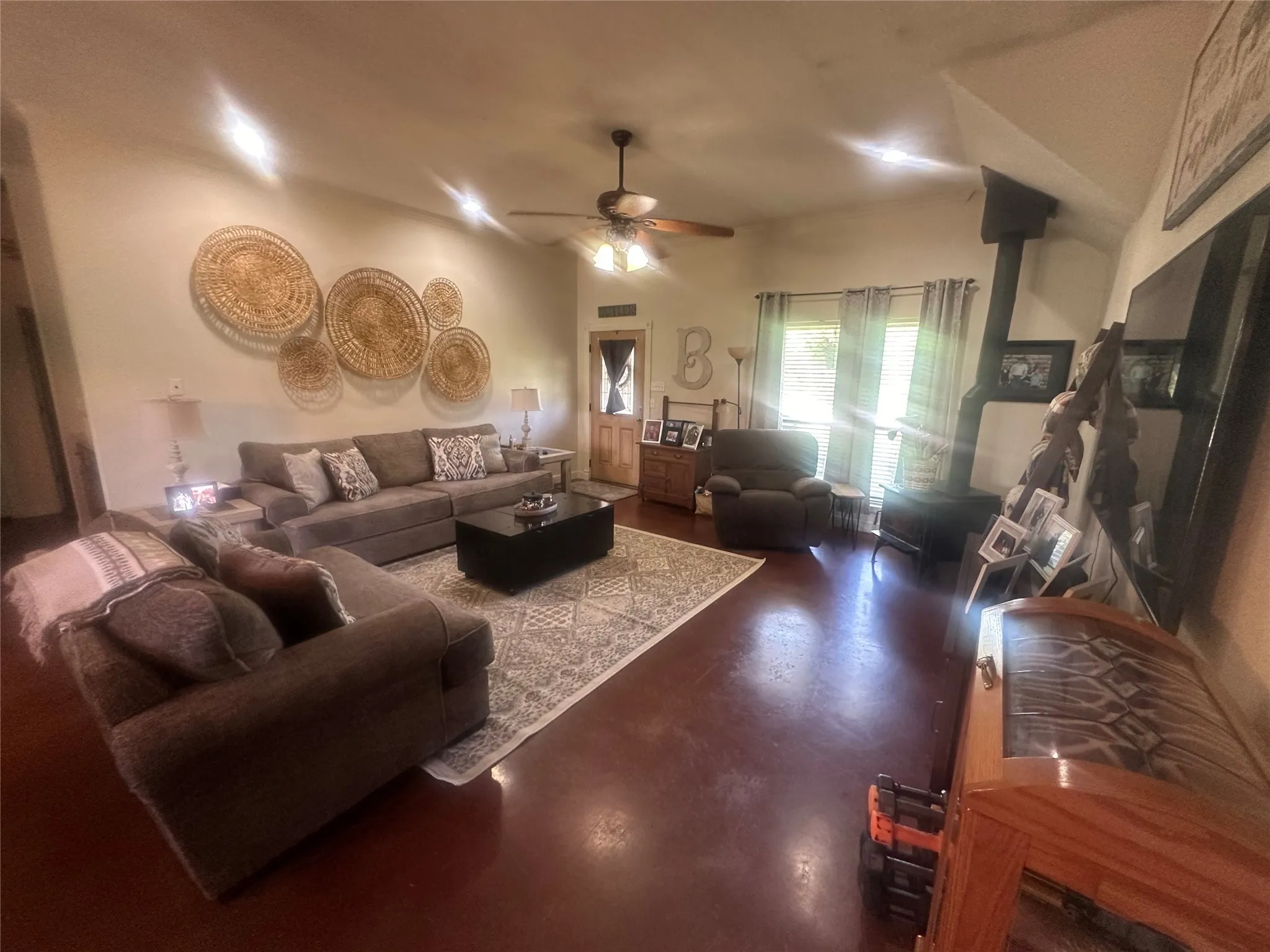 Living room featuring ceiling fan and a wood stove