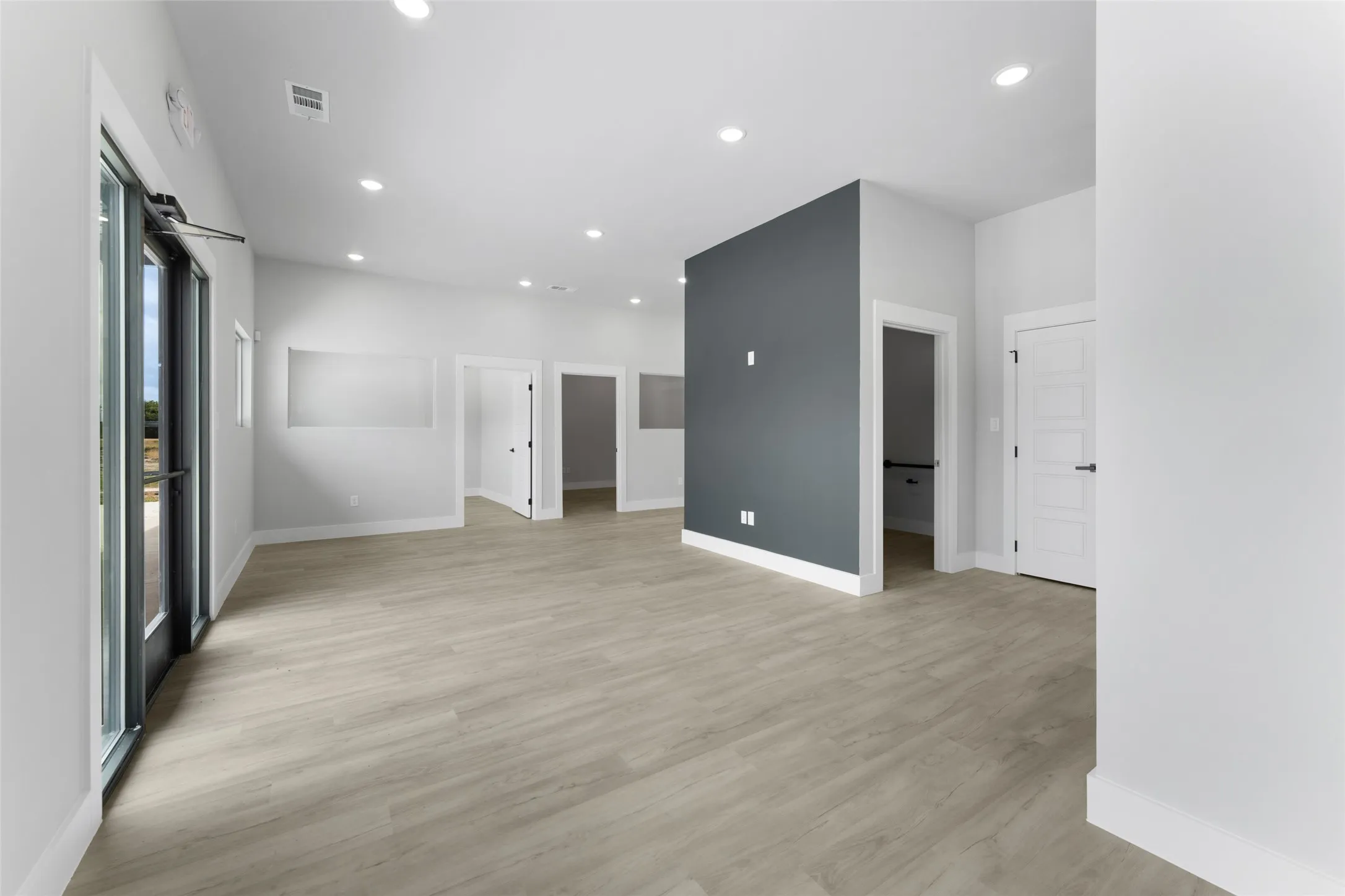 Empty room with light wood-type flooring and a barn door
