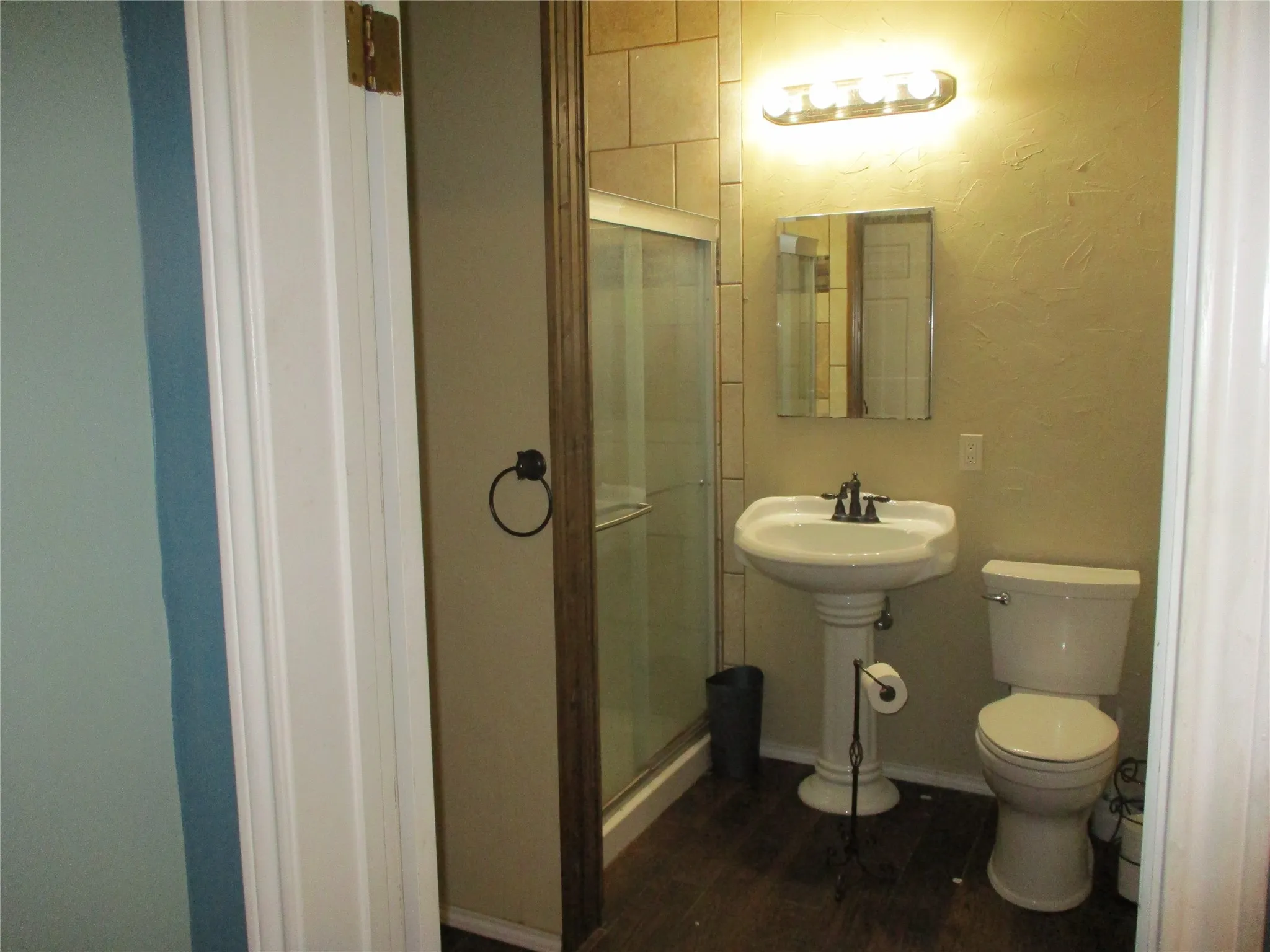Bathroom with toilet, wood-type flooring, and walk in shower