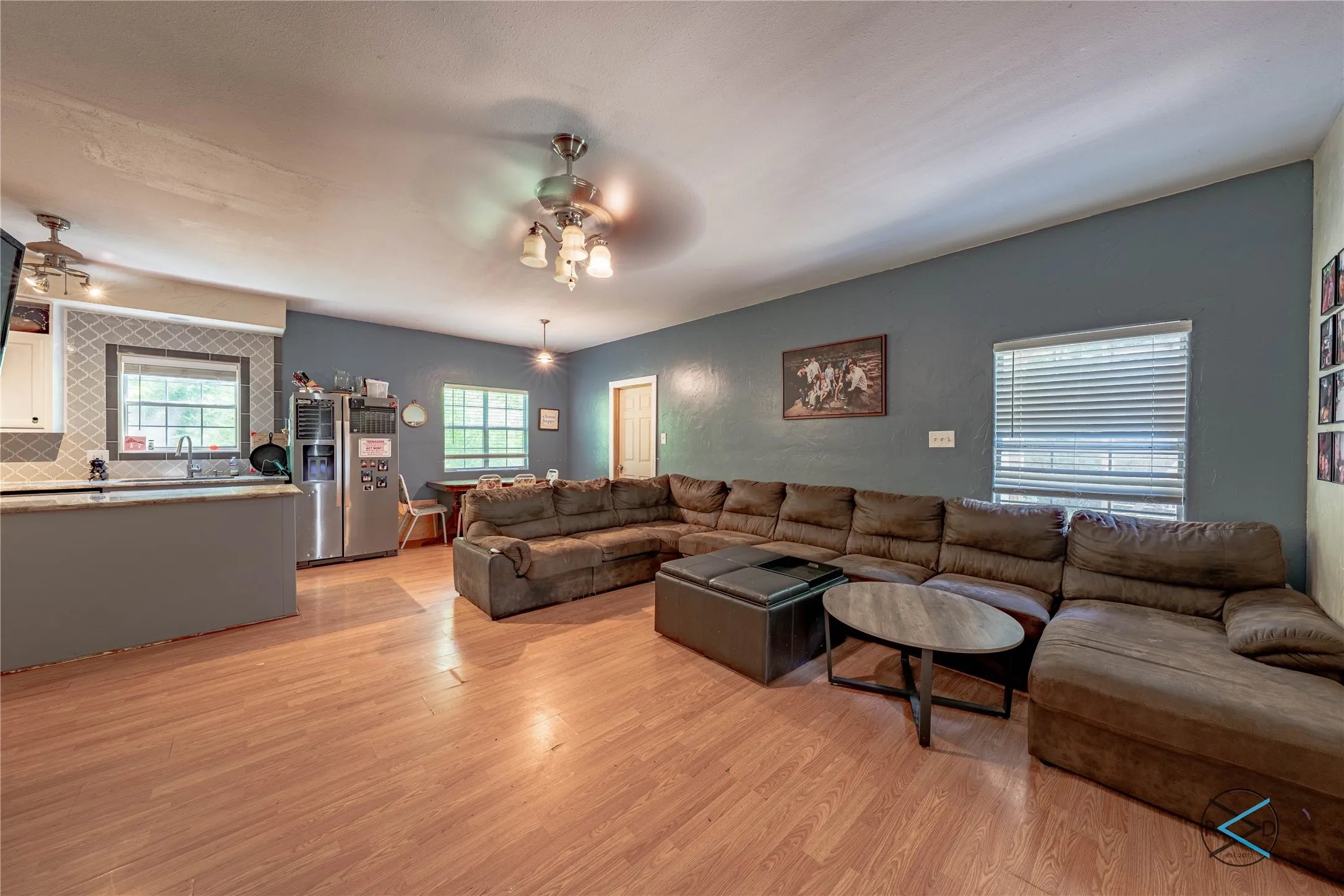 Living room featuring sink, light wood-type flooring, and ceiling fan