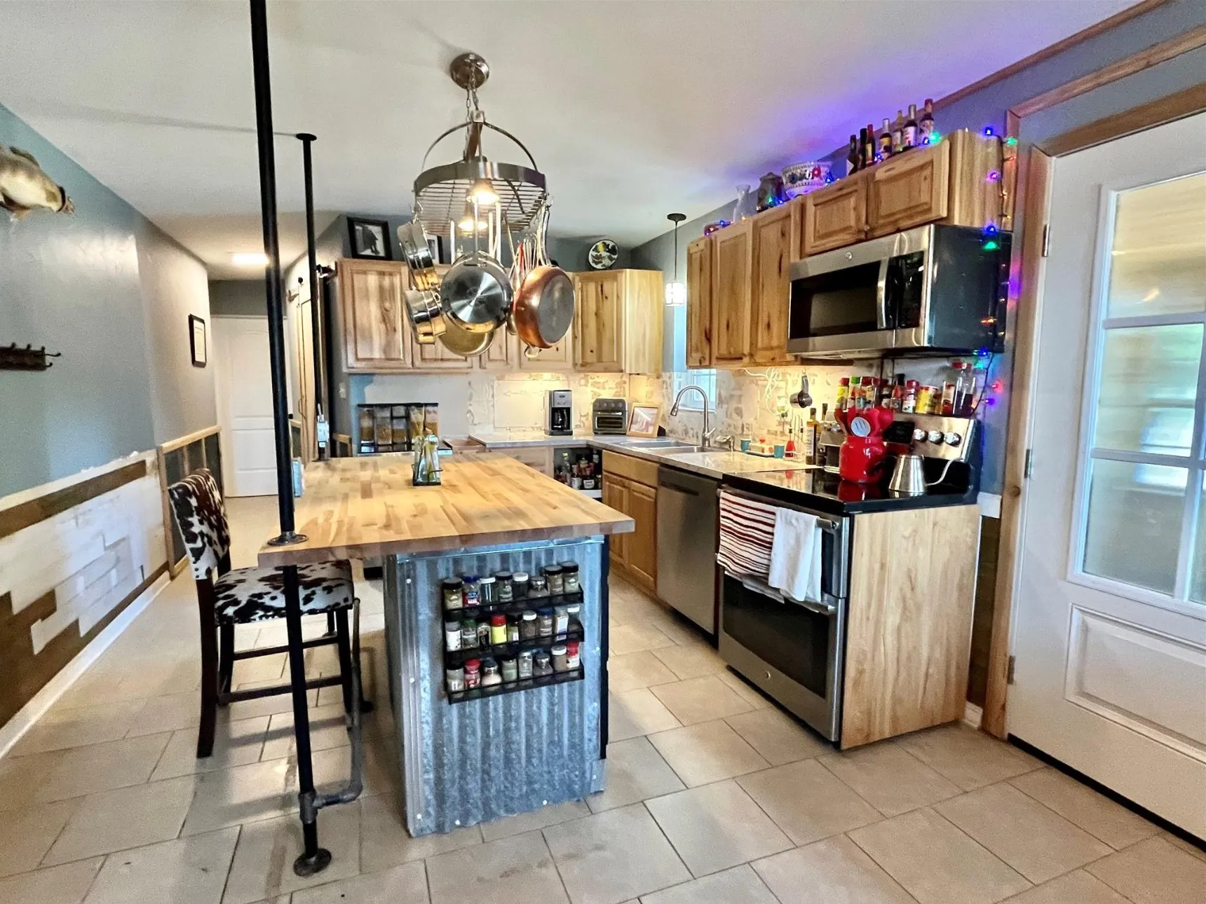 Kitchen with light tile patterned floors, a center island, tasteful backsplash, and stainless steel appliances