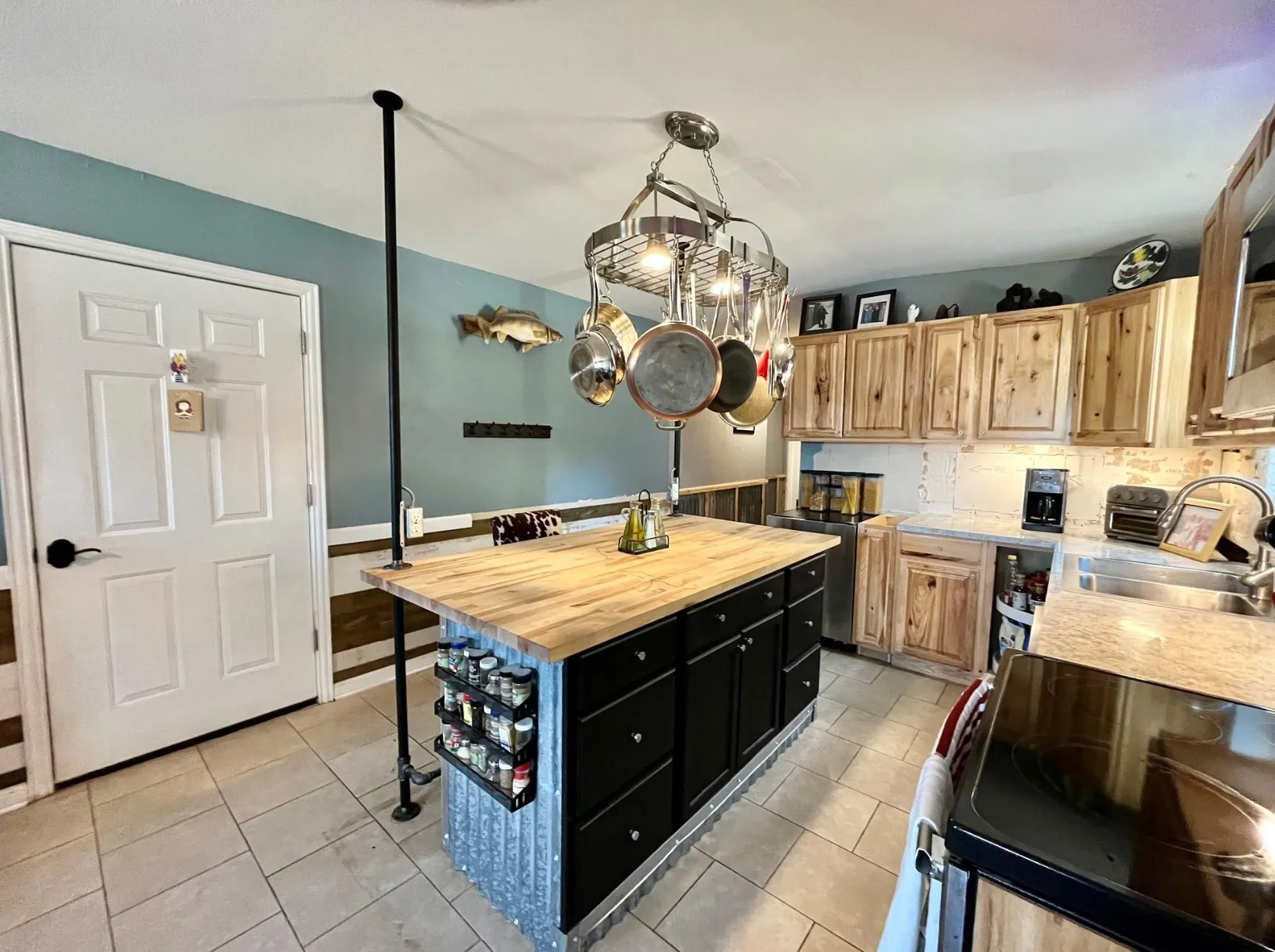 Kitchen featuring range, tasteful backsplash, butcher block counters, light tile patterned floors, and sink