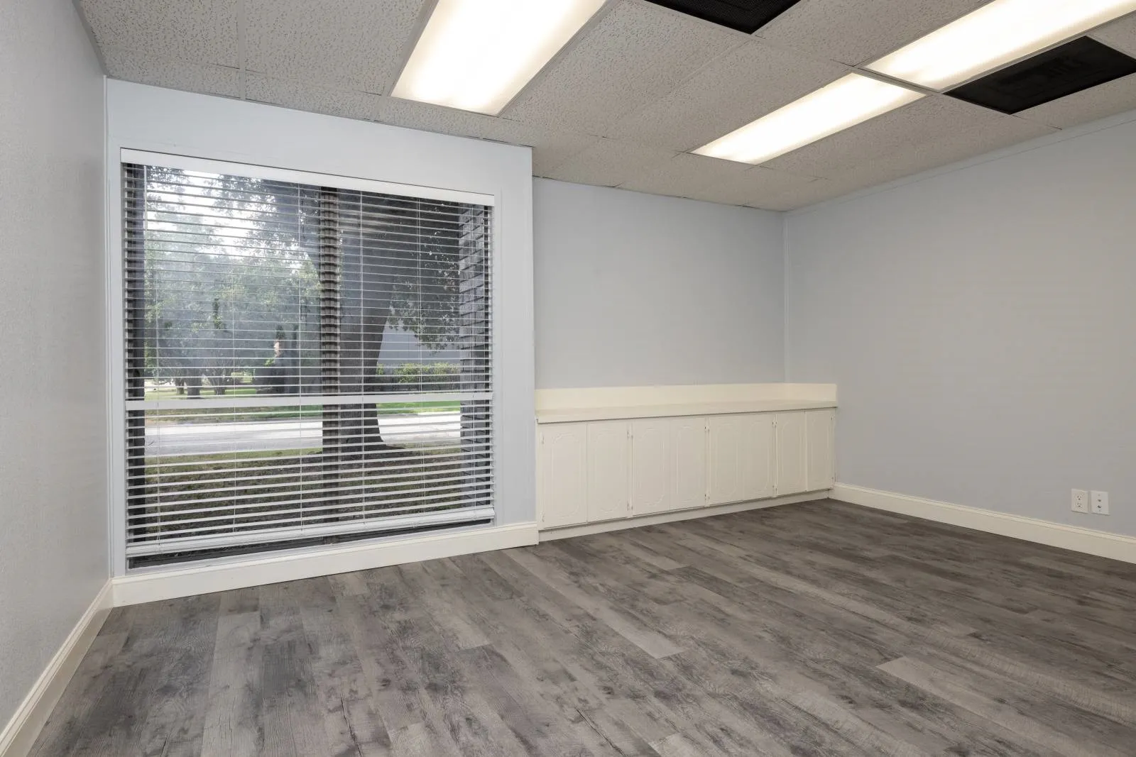 Unfurnished room featuring hardwood / wood-style flooring and a paneled ceiling
