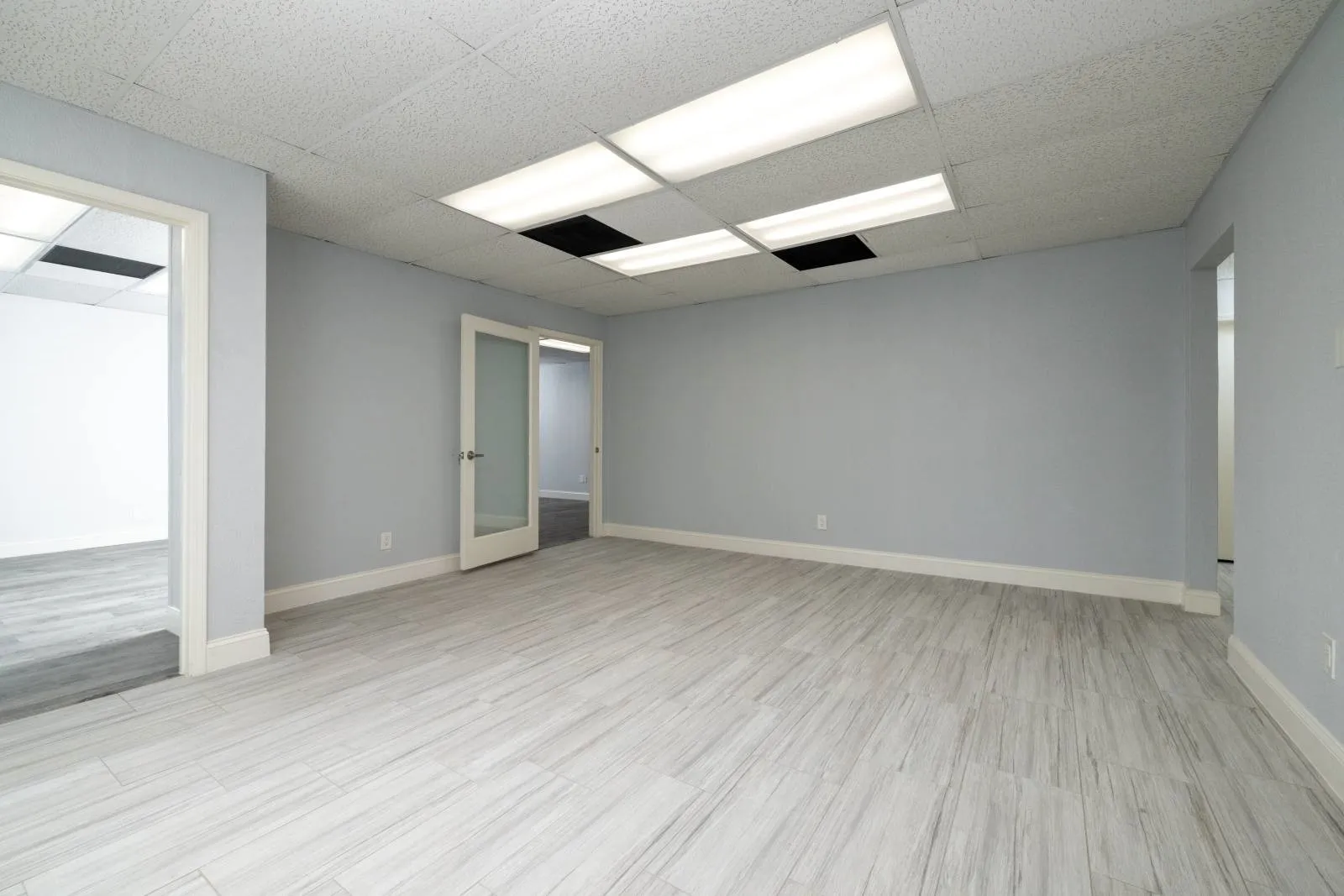 Spare room featuring light wood-type flooring and a drop ceiling