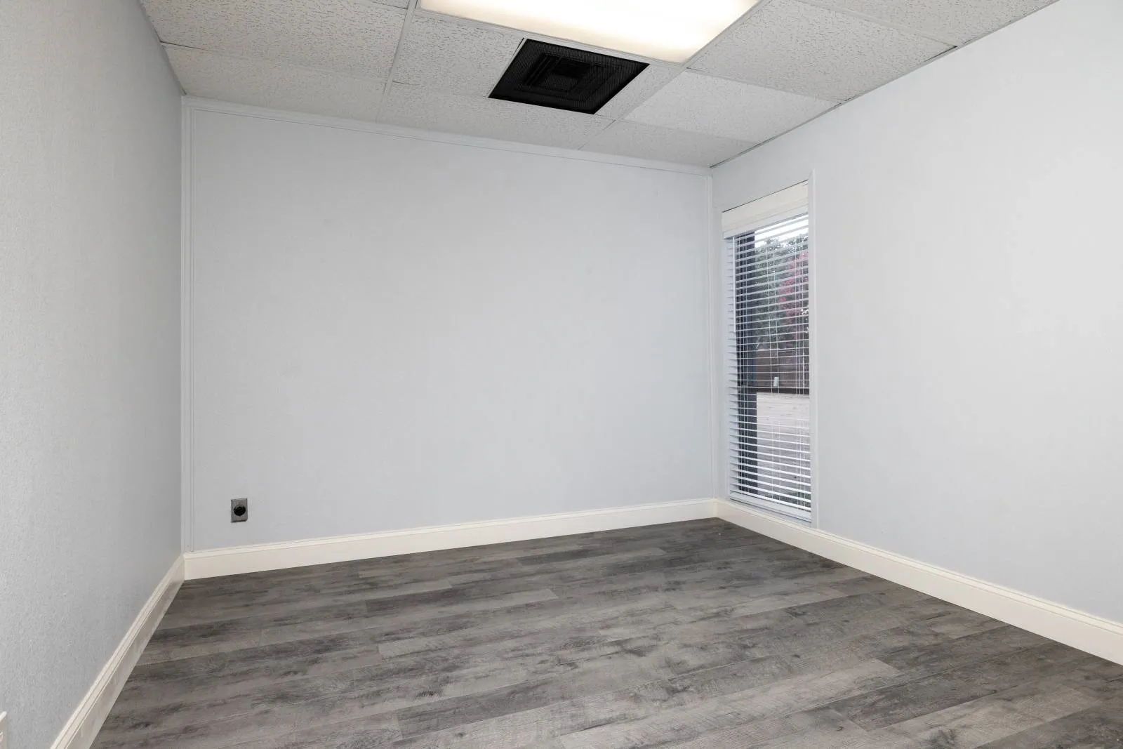 Unfurnished room featuring dark wood-type flooring and a paneled ceiling