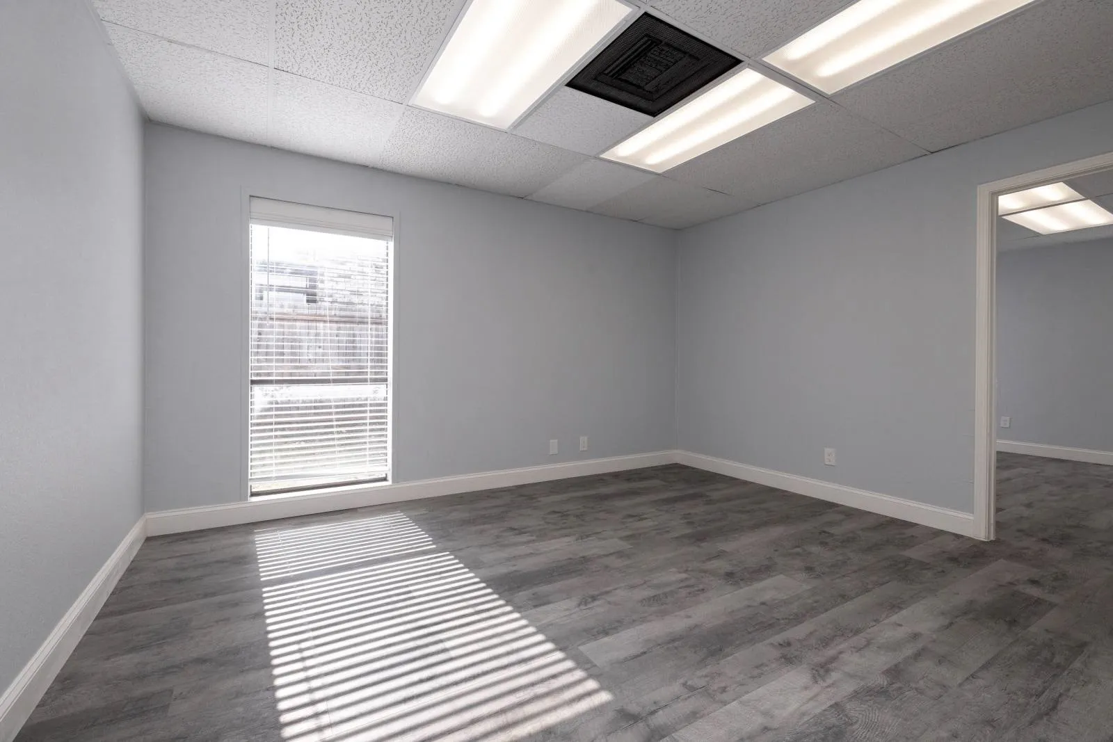 Empty room featuring hardwood / wood-style flooring and a paneled ceiling