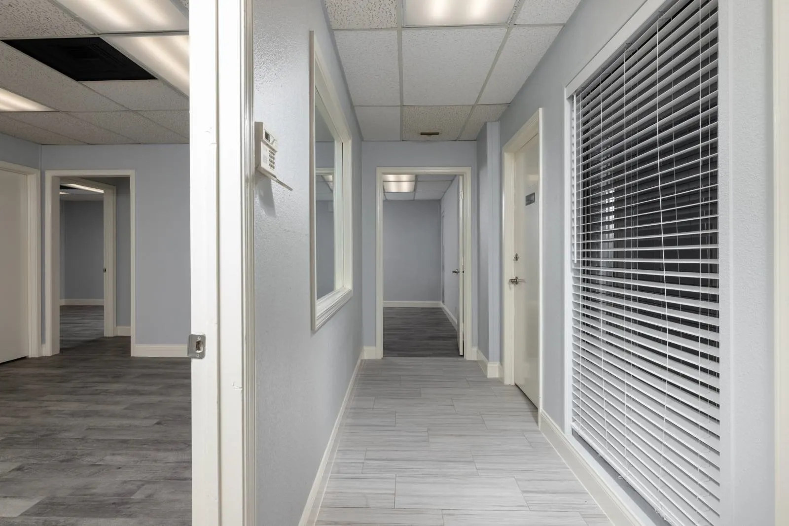 Hallway with hardwood / wood-style flooring and a paneled ceiling